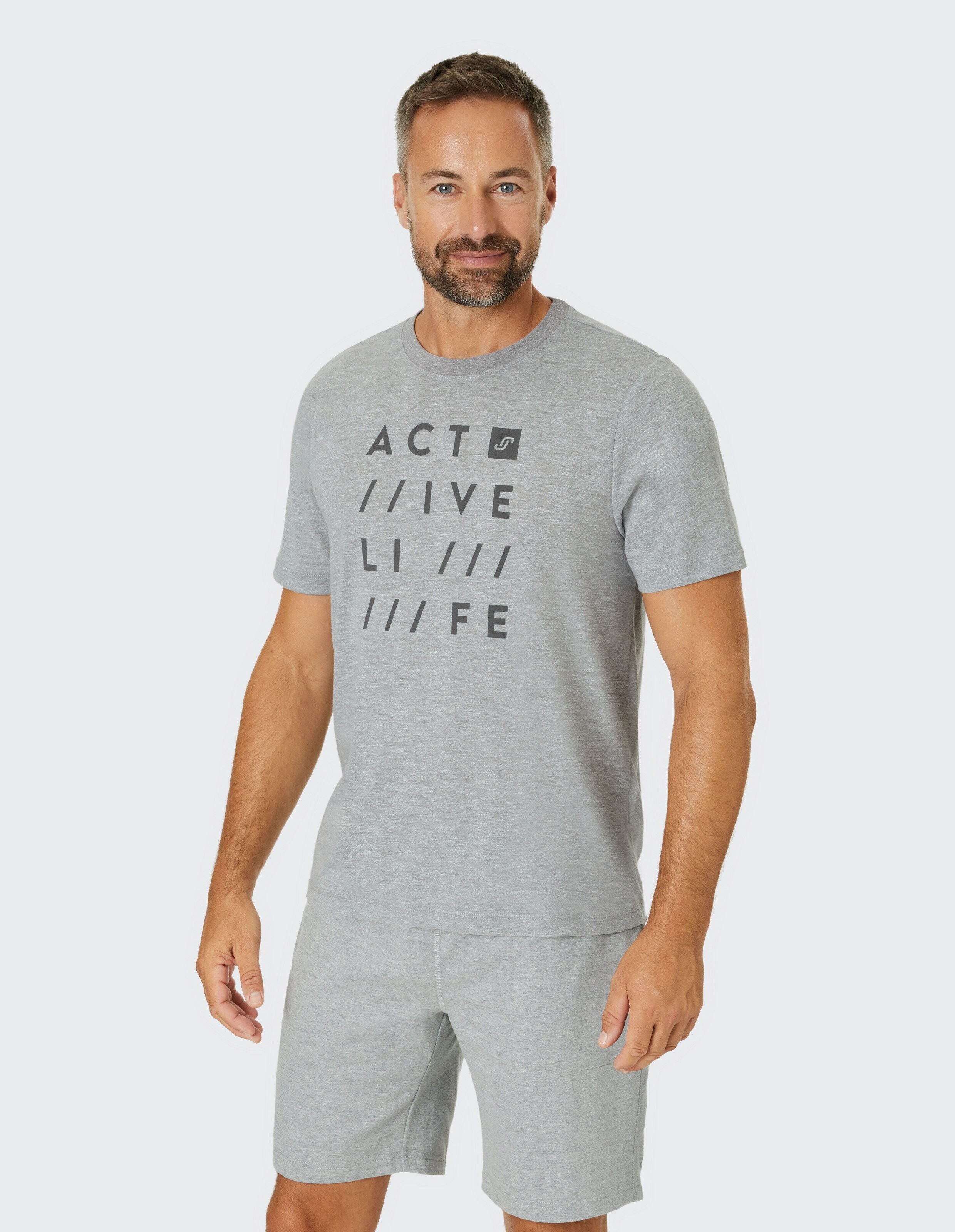Mann trägt ein graues Freizeit-T-Shirt mit Grafikdruck für bequeme Loungewear.