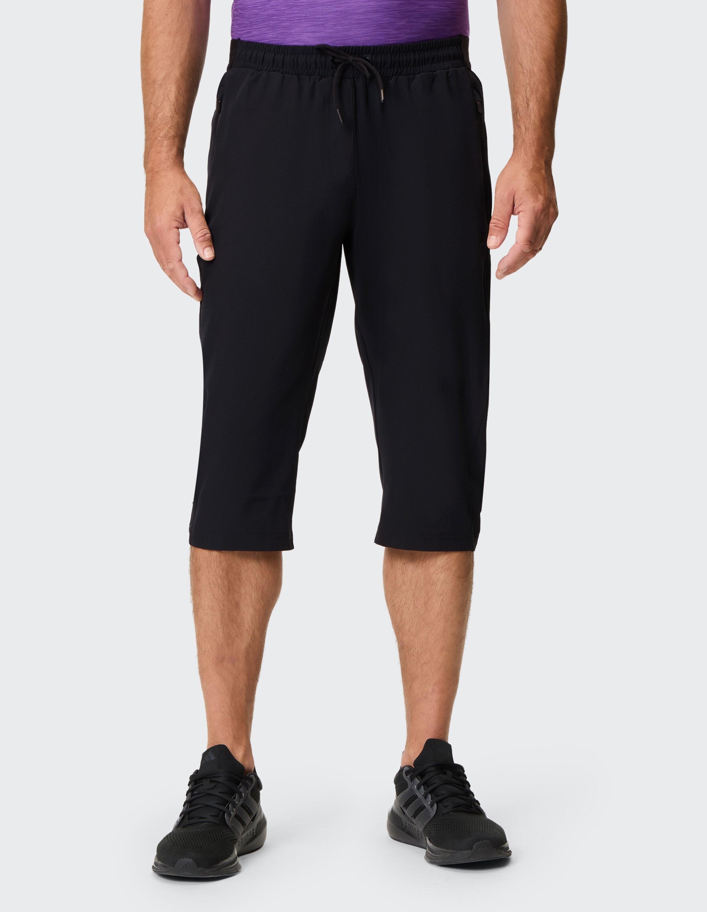 Mann trägt schwarze, lässige Dreiviertel-Shorts mit Kordelzug in der Taille.