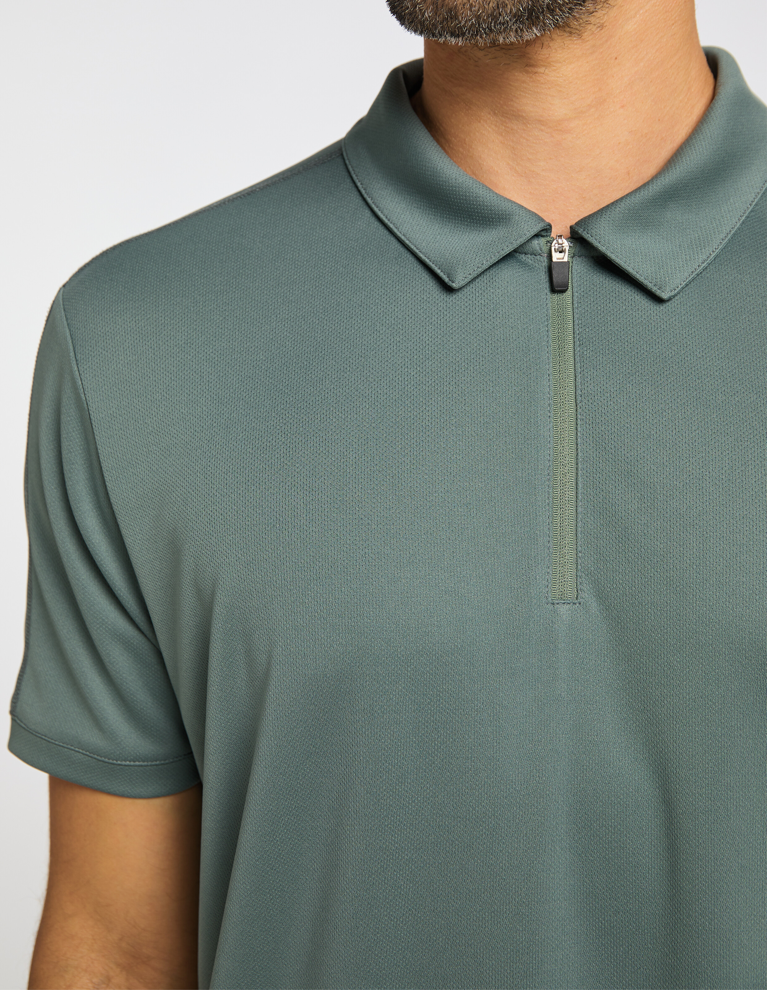 Lässiges Herren-Poloshirt in gedecktem Grün mit Reißverschlusskragen und kurzen Ärmeln.