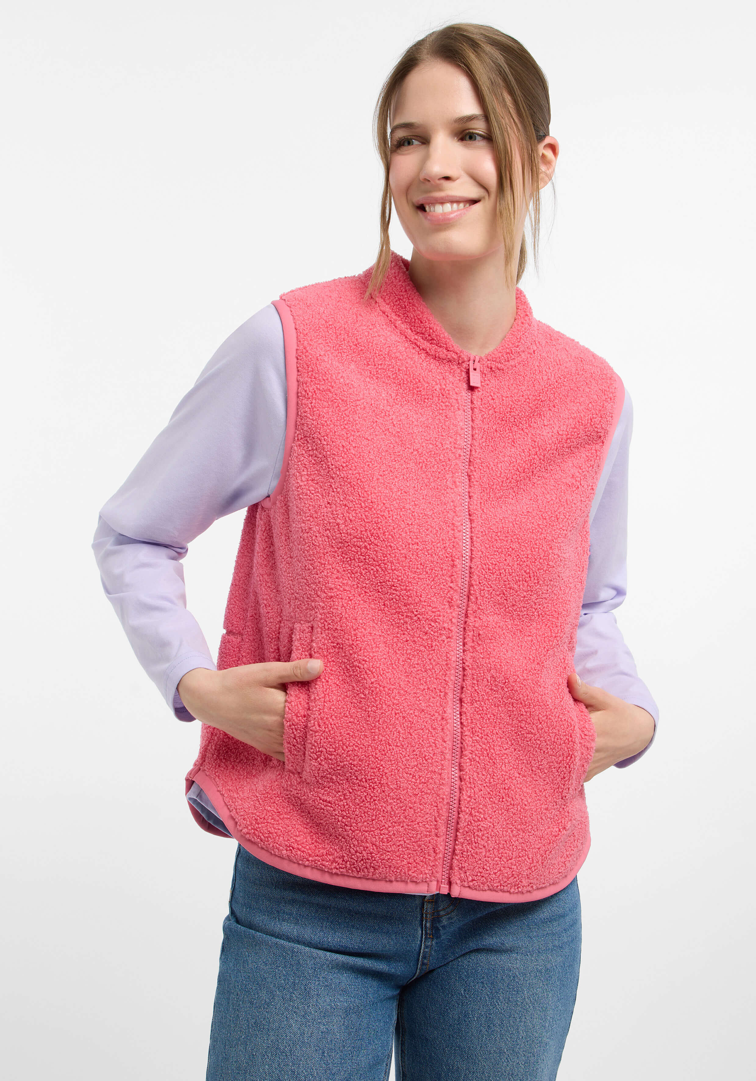Kuschelige rosafarbene Fleeceweste mit Taschen, gepaart mit einem hellvioletten Langarmshirt.