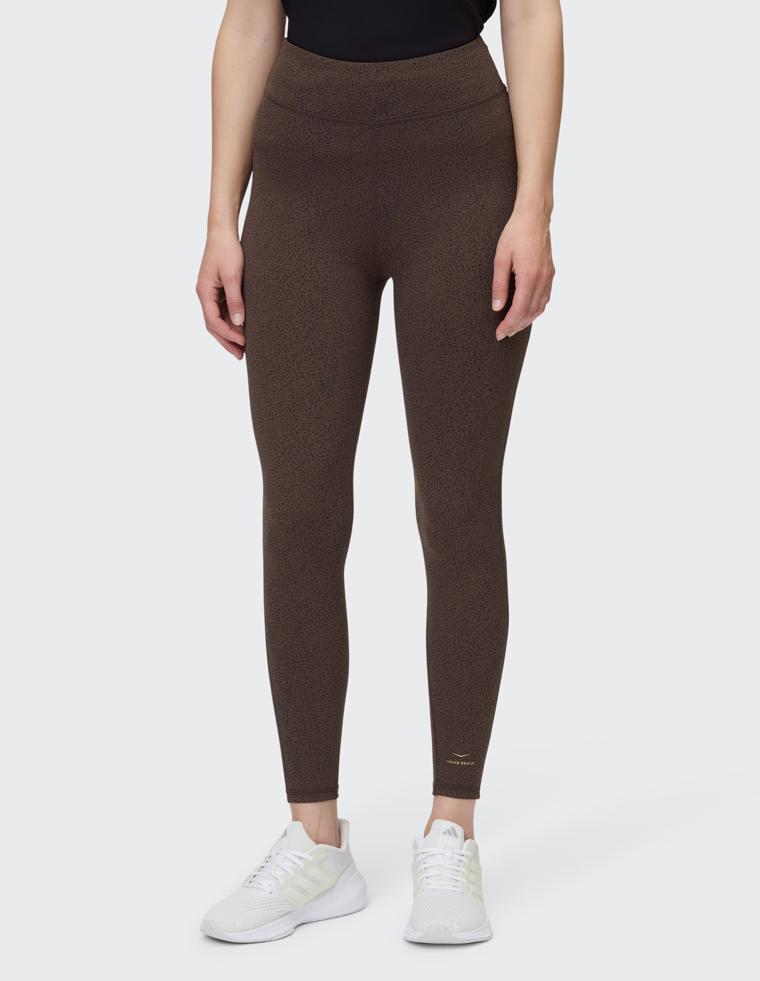 Frau trägt braune Leggings mit hohem Bund und dezentem Muster für lässige Lounge-Kleidung.