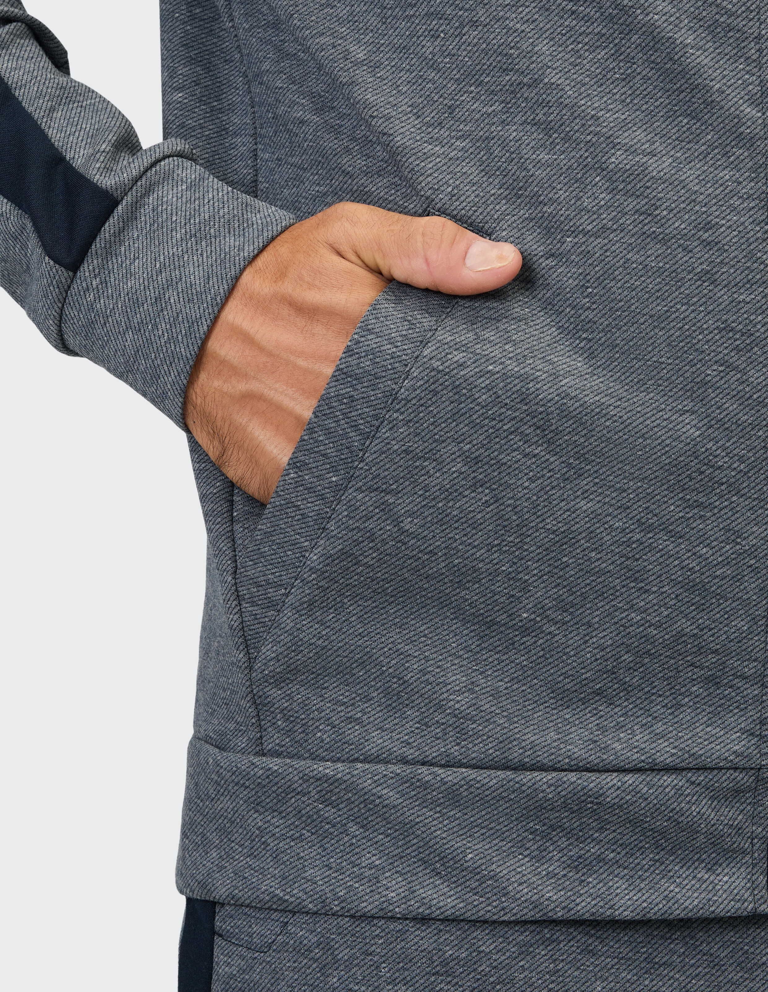 Nahaufnahme einer grauen Freizeitjacke mit einer Hand in der Tasche, die die Textur zeigt.