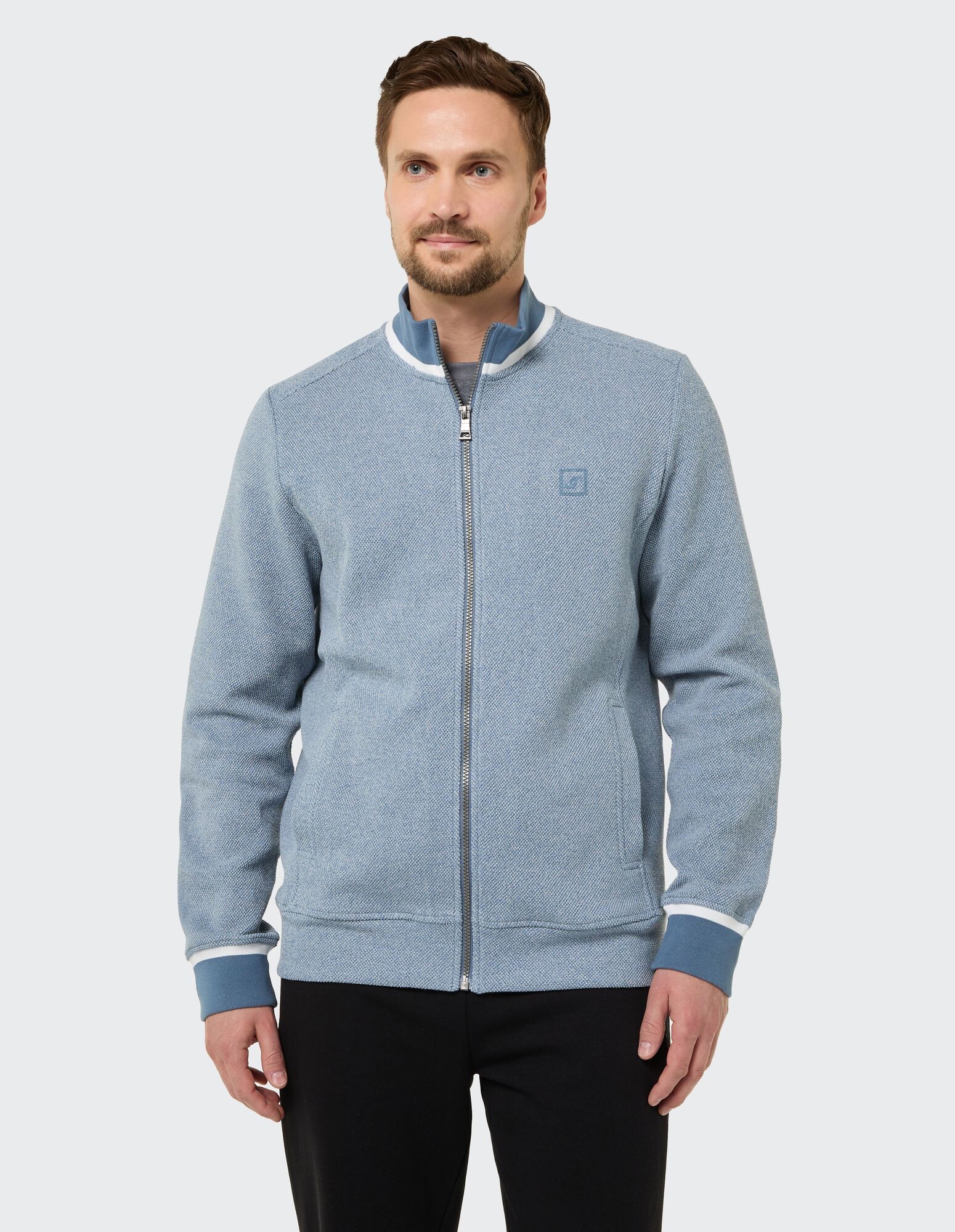 Hellblaue Herrenjacke mit Reißverschluss, strukturierter Oberfläche und kontrastierenden Bündchen.