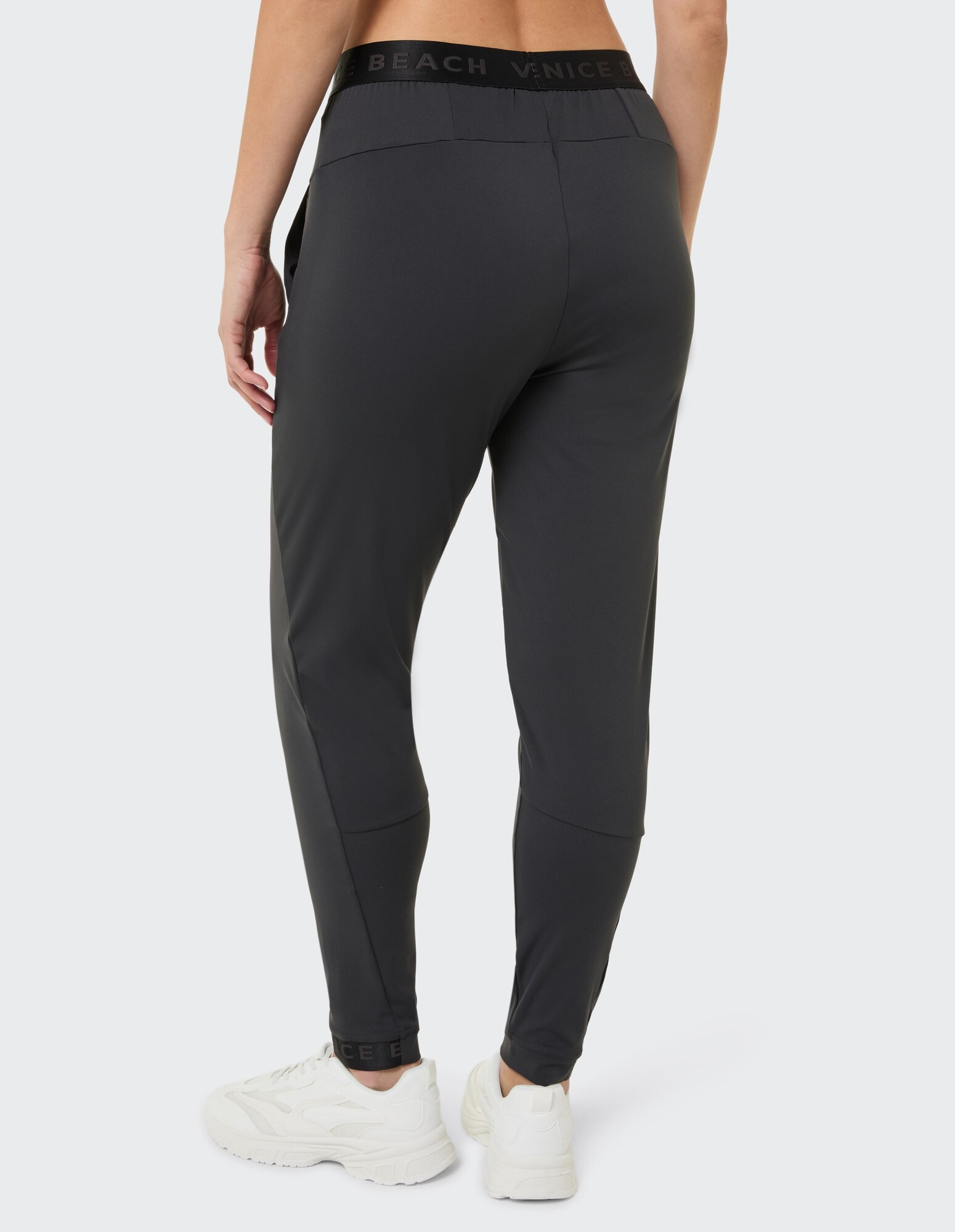 Rückansicht einer schwarzen Freizeithose mit elastischem Bund und sportlichem Design.