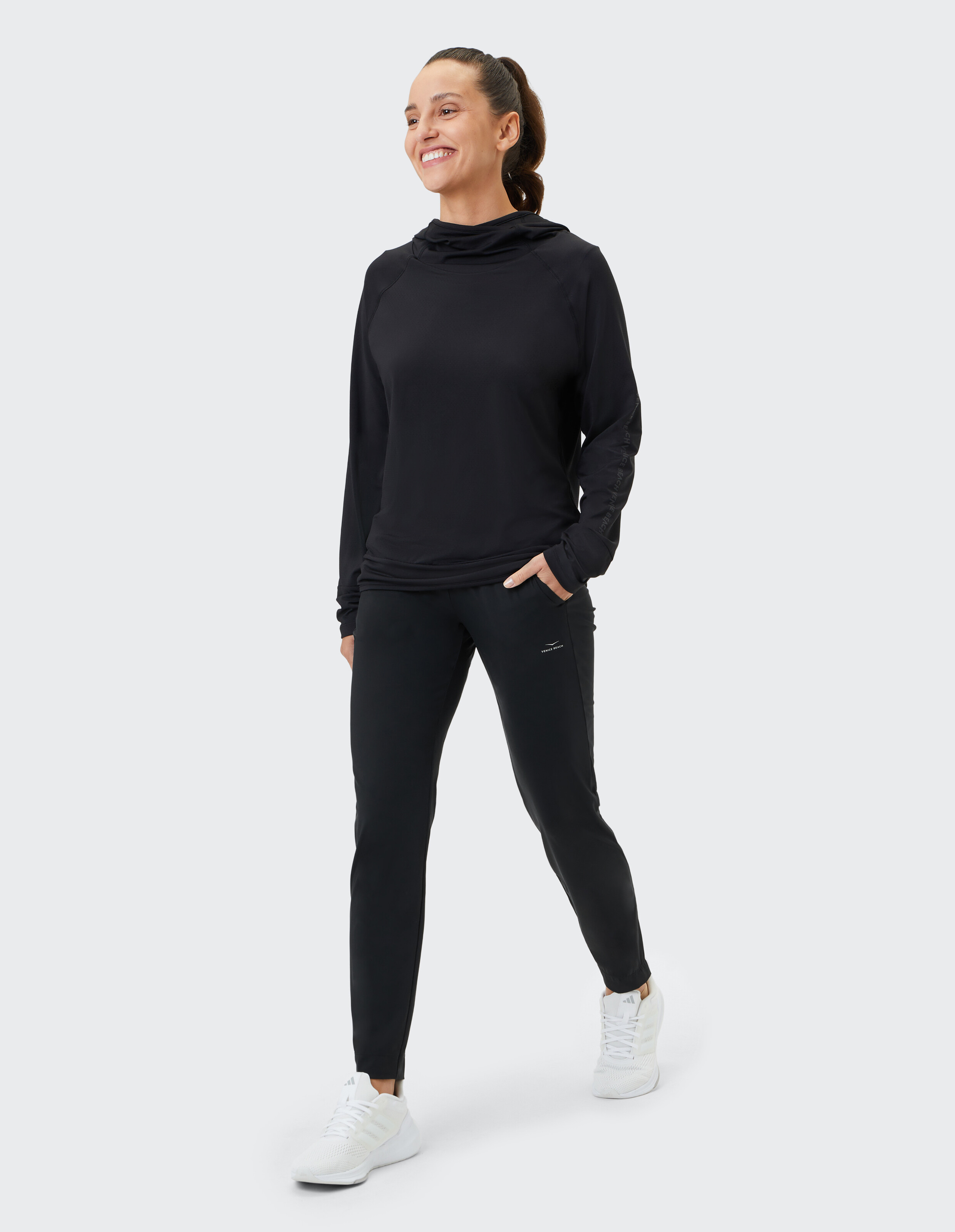 Frau in schwarzem Kapuzenpullover und Hose, perfekt für Freizeitkleidung und Faulenzen.