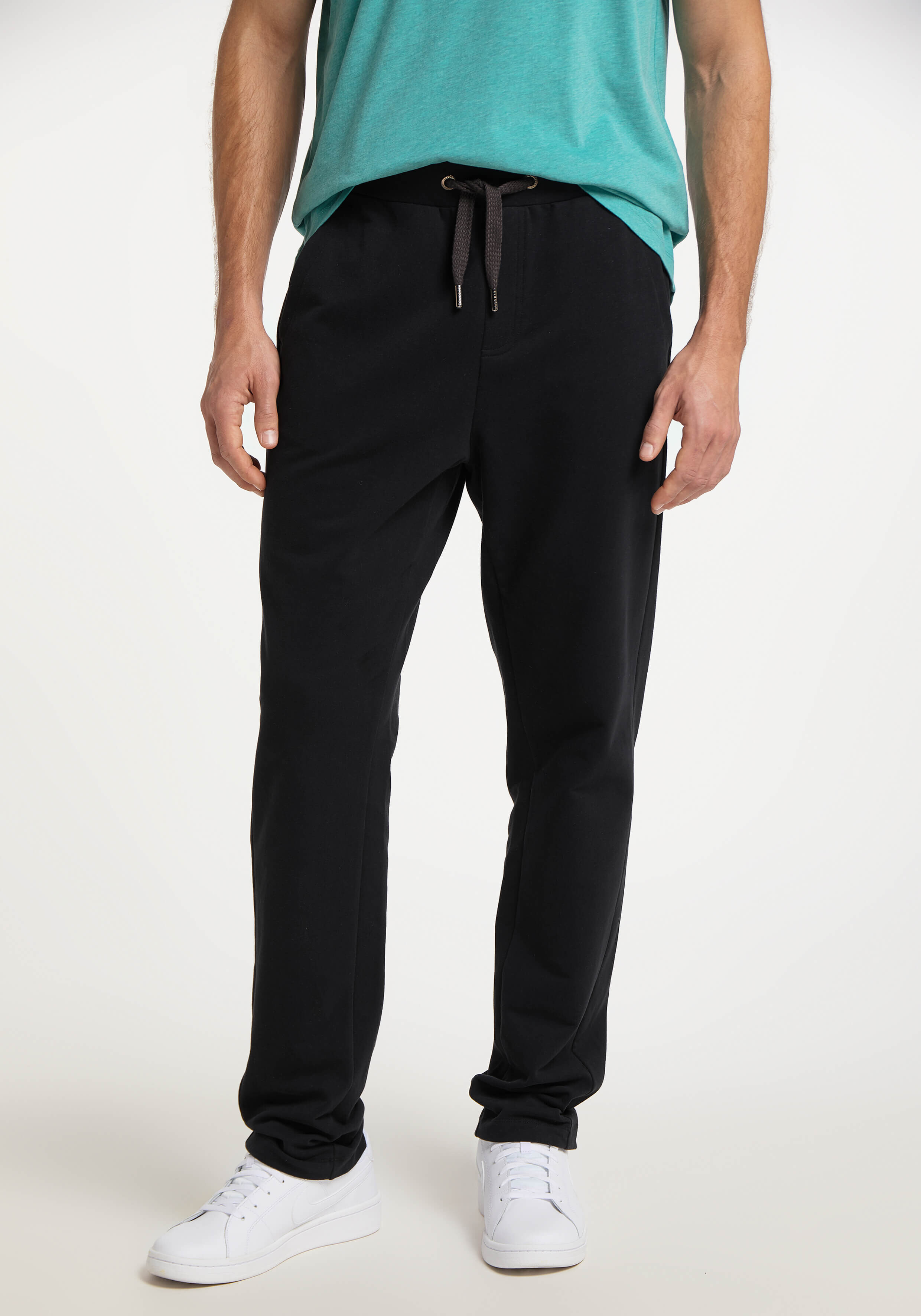 Mann trägt bequeme schwarze Freizeit-Jogginghose mit Kordelzug in der Taille.