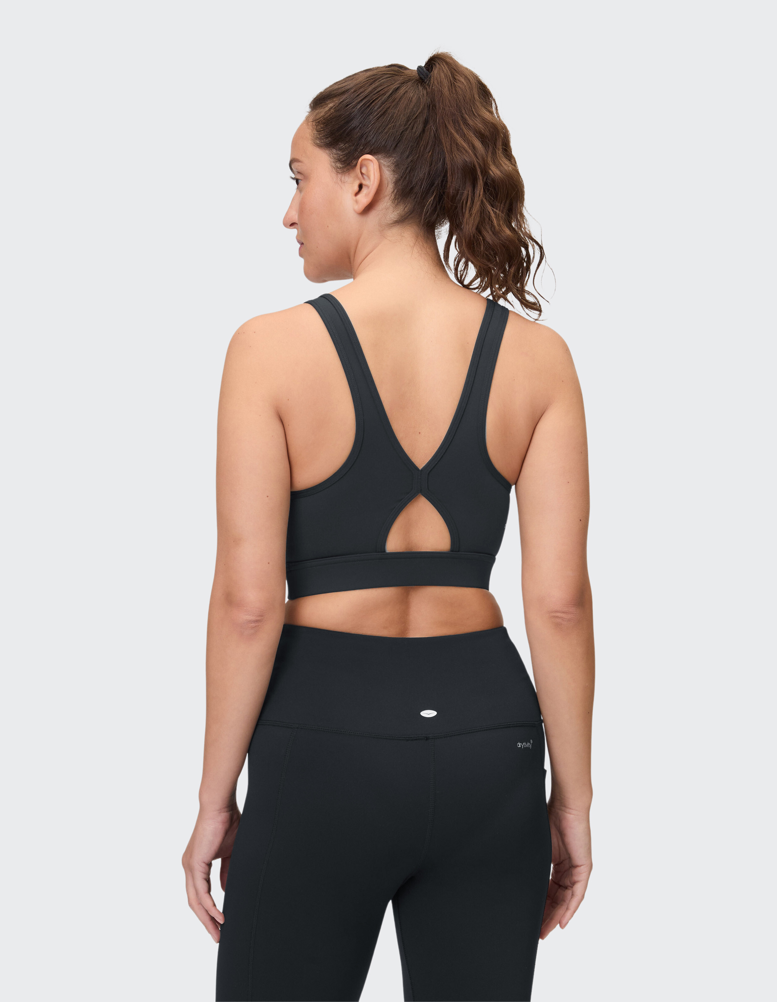 Frau trägt einen schwarzen Sport-BH und Leggings für lässige Sportkleidung.