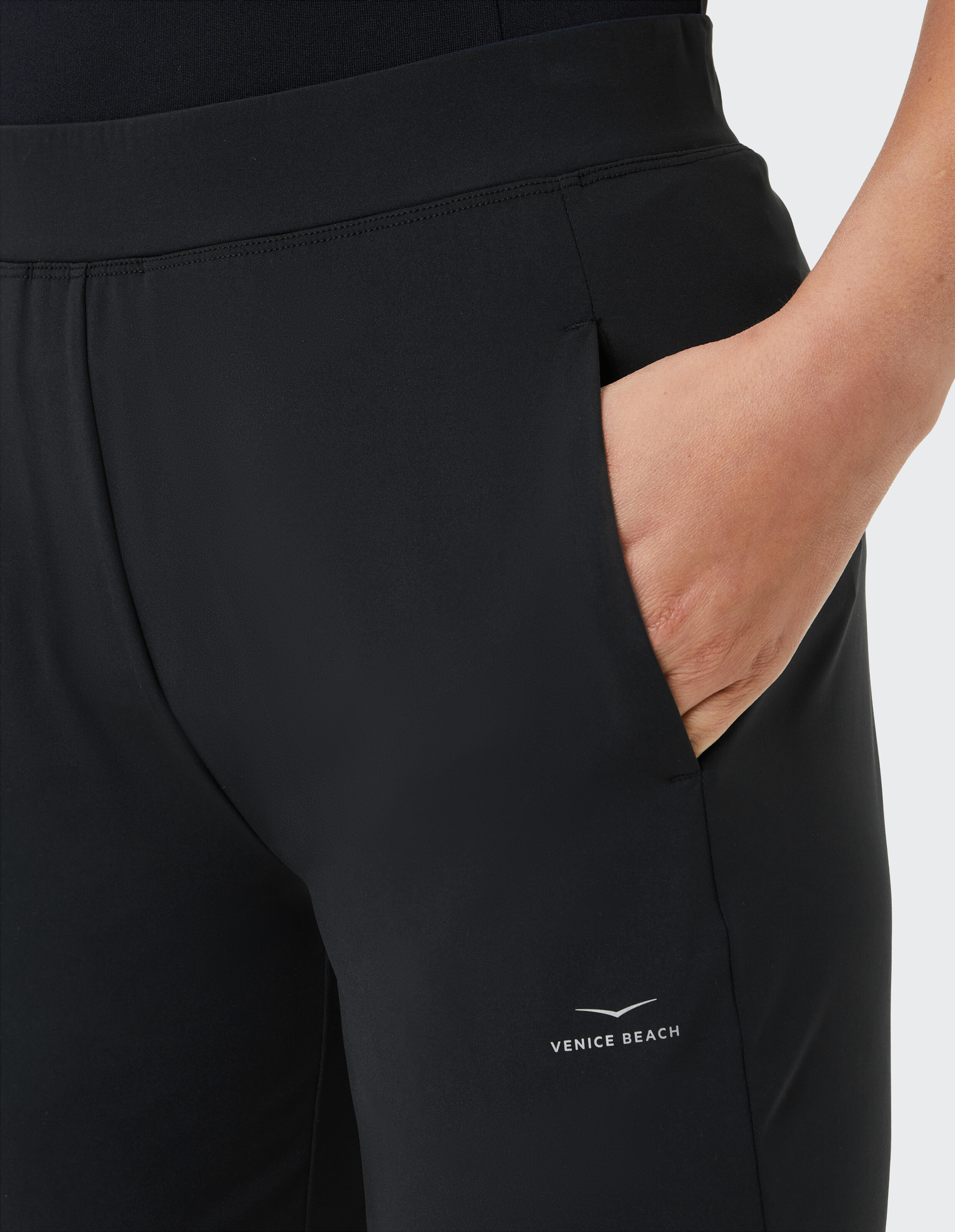Nahaufnahme einer schwarzen Freizeithose mit Taschen und Venice Beach-Logo.
