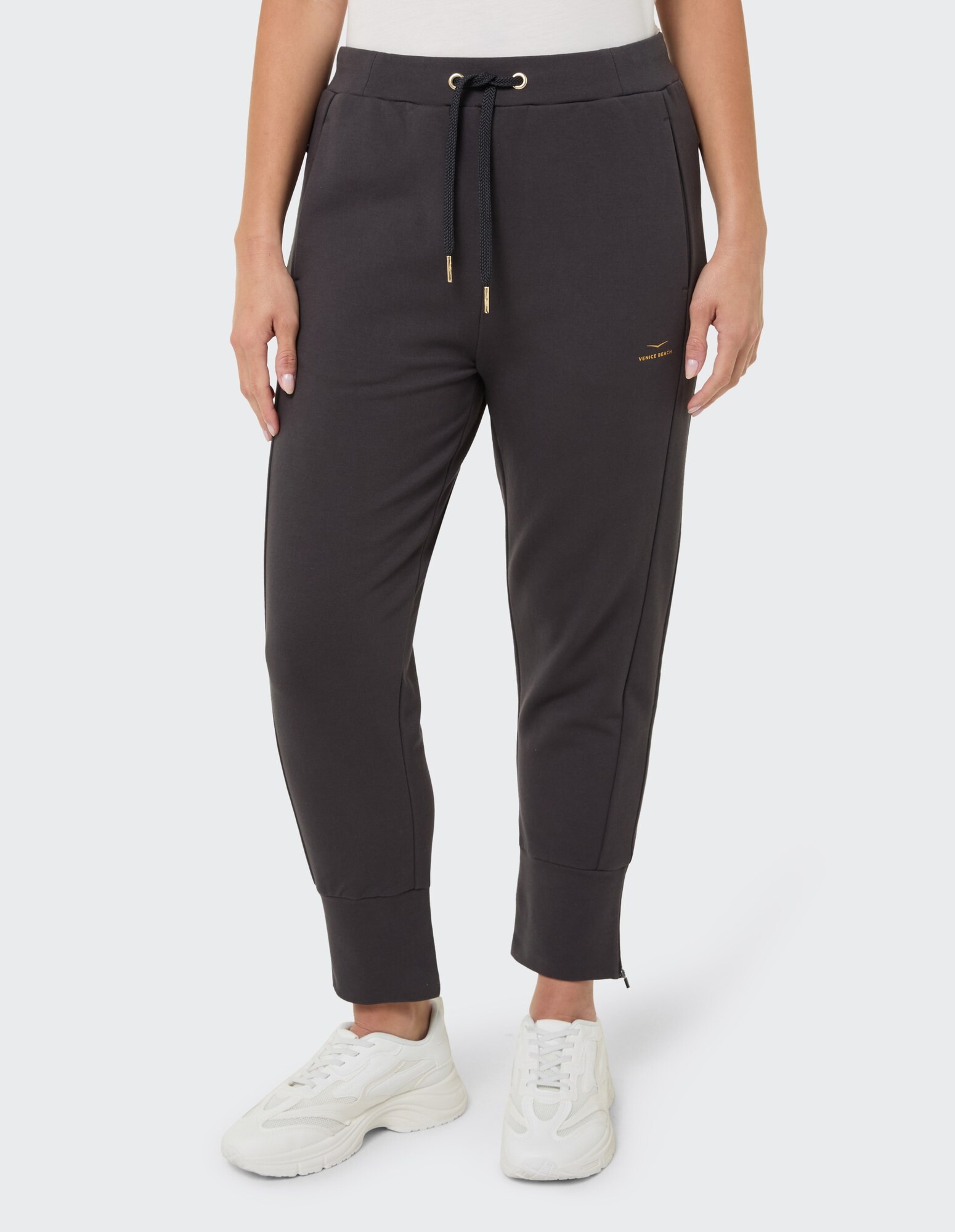 Dunkelgraue Jogginghose für Damen mit Kordelzug und Reißverschlussbündchen, perfekt für den Freizeitgebrauch.