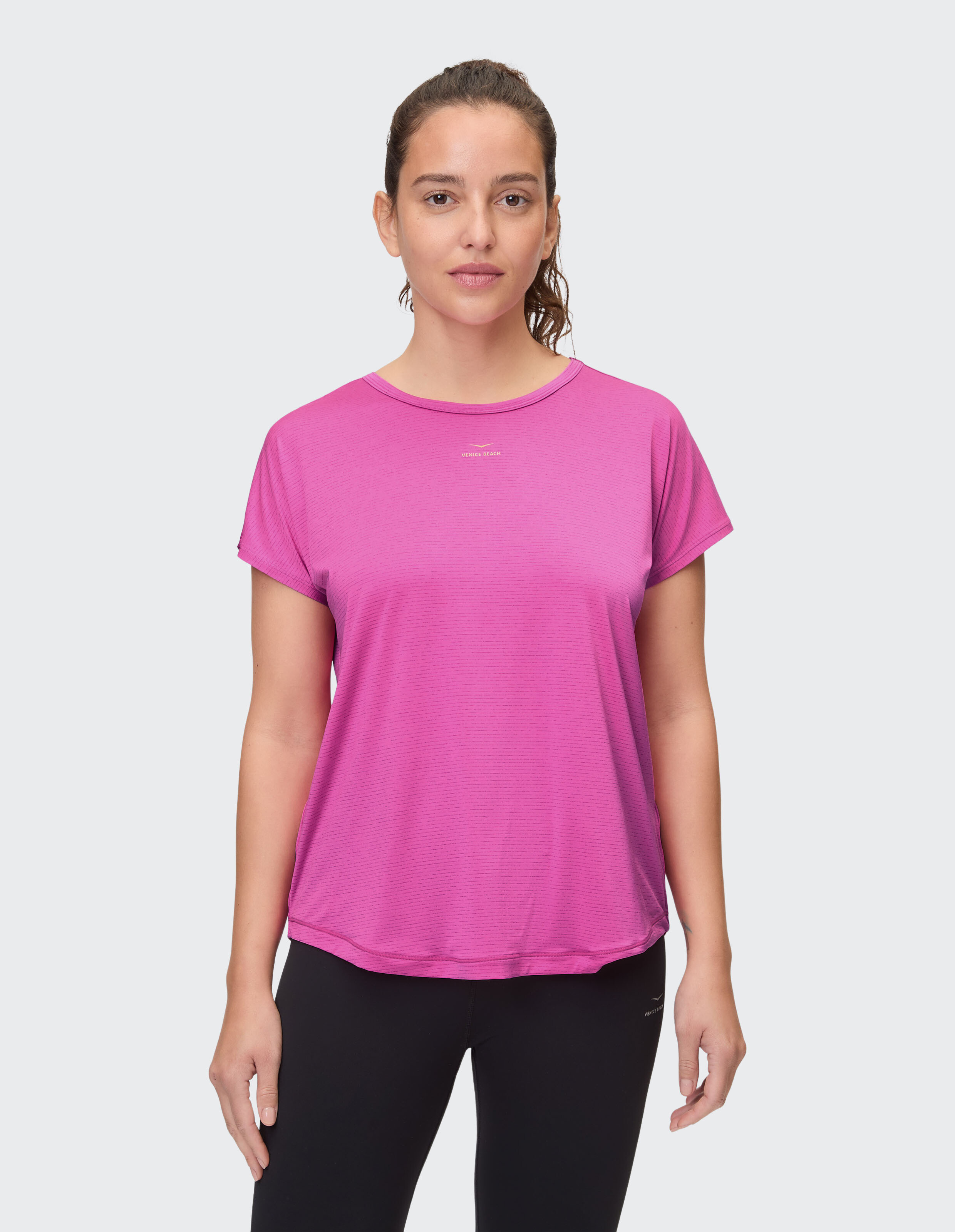 Frau trägt ein rosa lässiges T-Shirt, perfekt für bequeme Alltagskleidung.