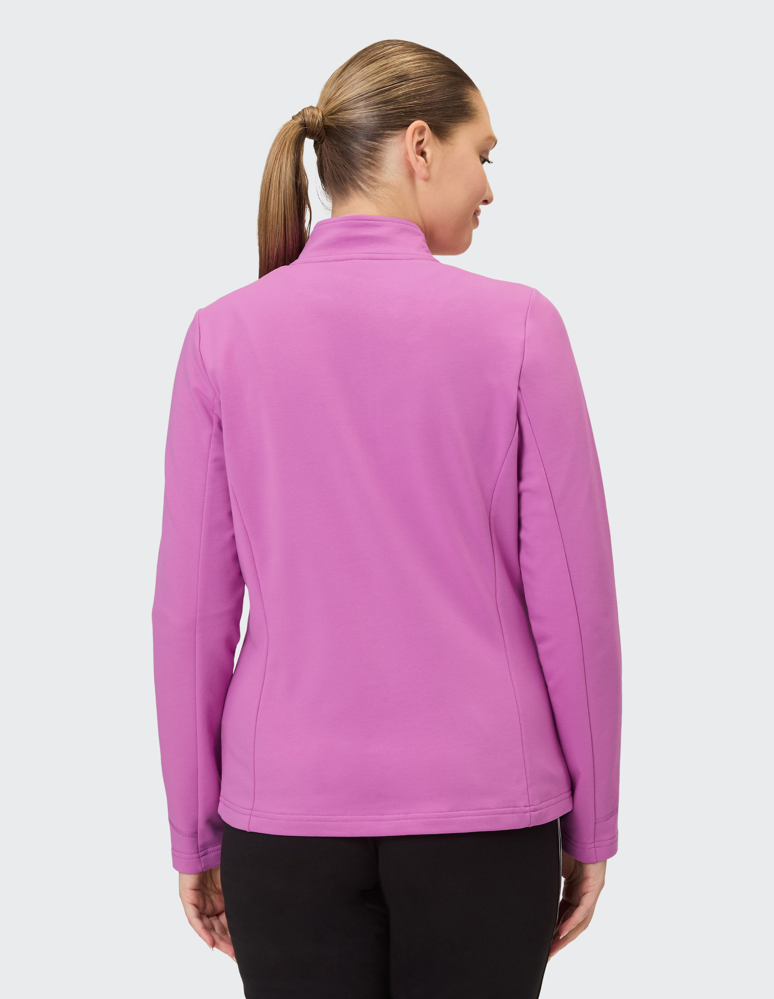 Rückansicht einer Frau, die eine rosa Freizeitjacke trägt, perfekt für gemütliche Ausflüge.