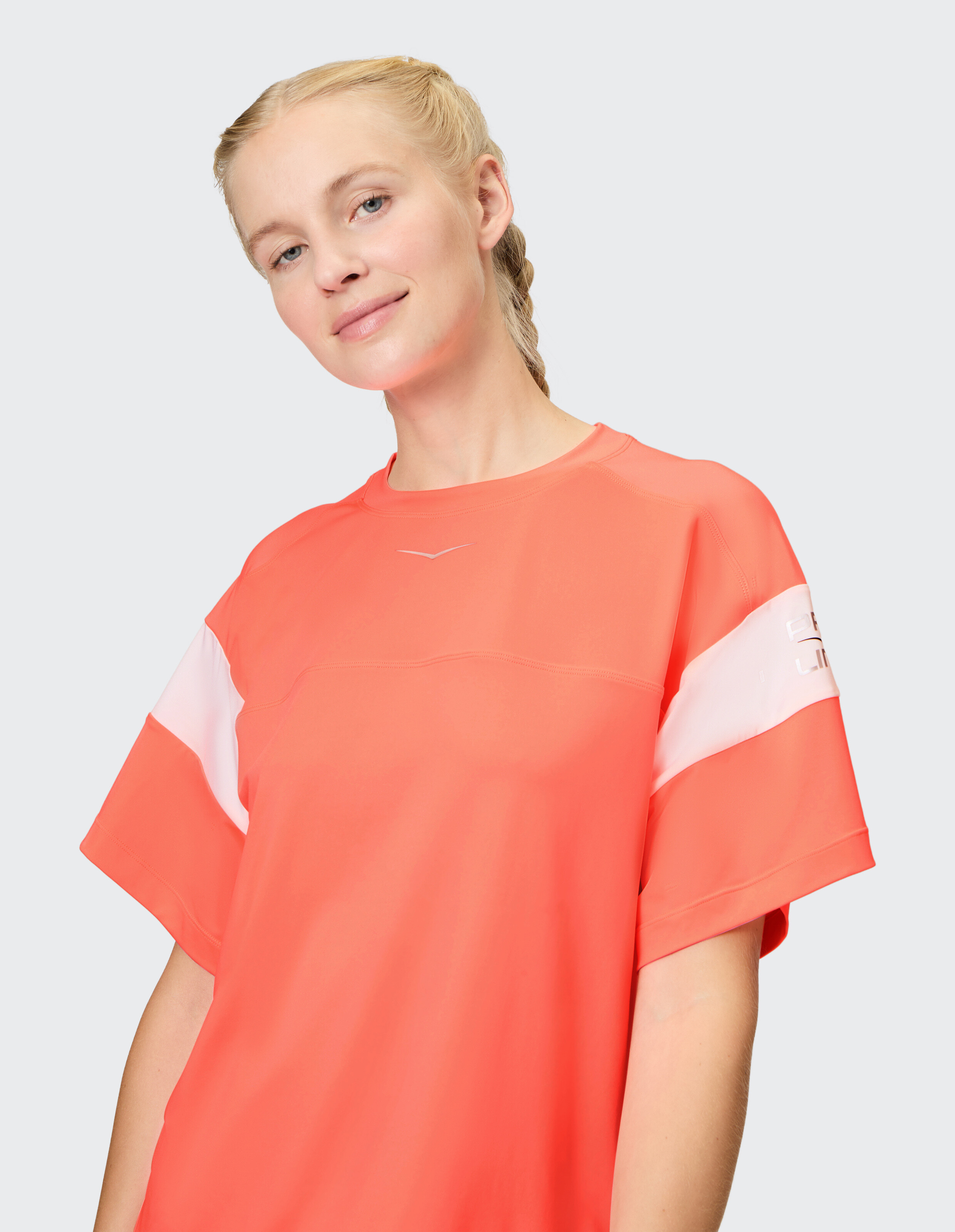 Lässiges T-Shirt in leuchtendem Korallenrot mit weißen Akzenten, perfekt für entspannte Ausflüge.