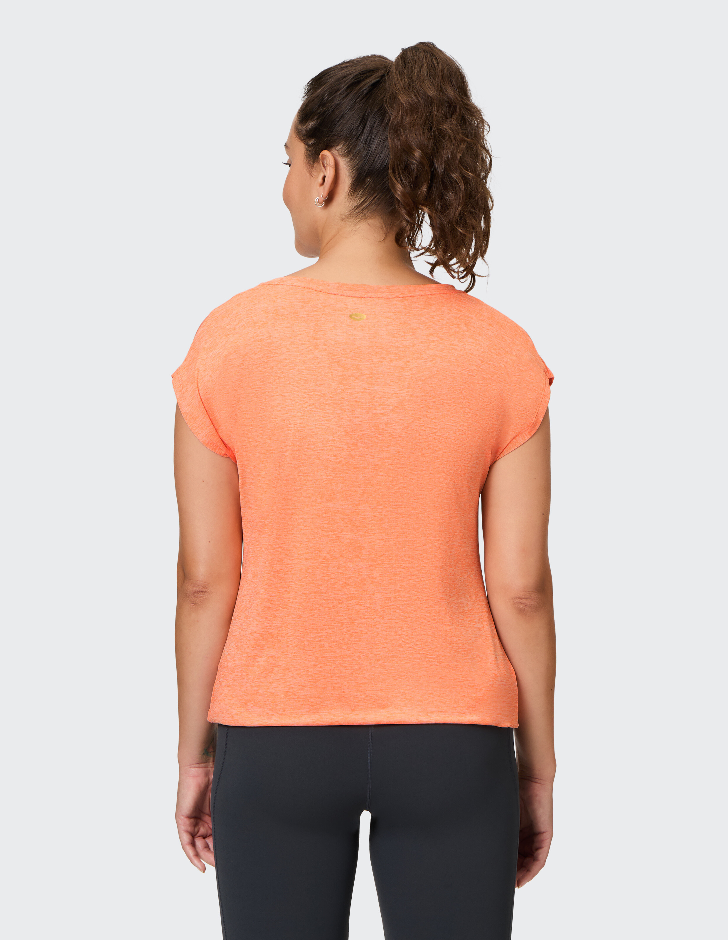 Frau trägt ein kuscheliges orangefarbenes T-Shirt zum entspannten Entspannen.