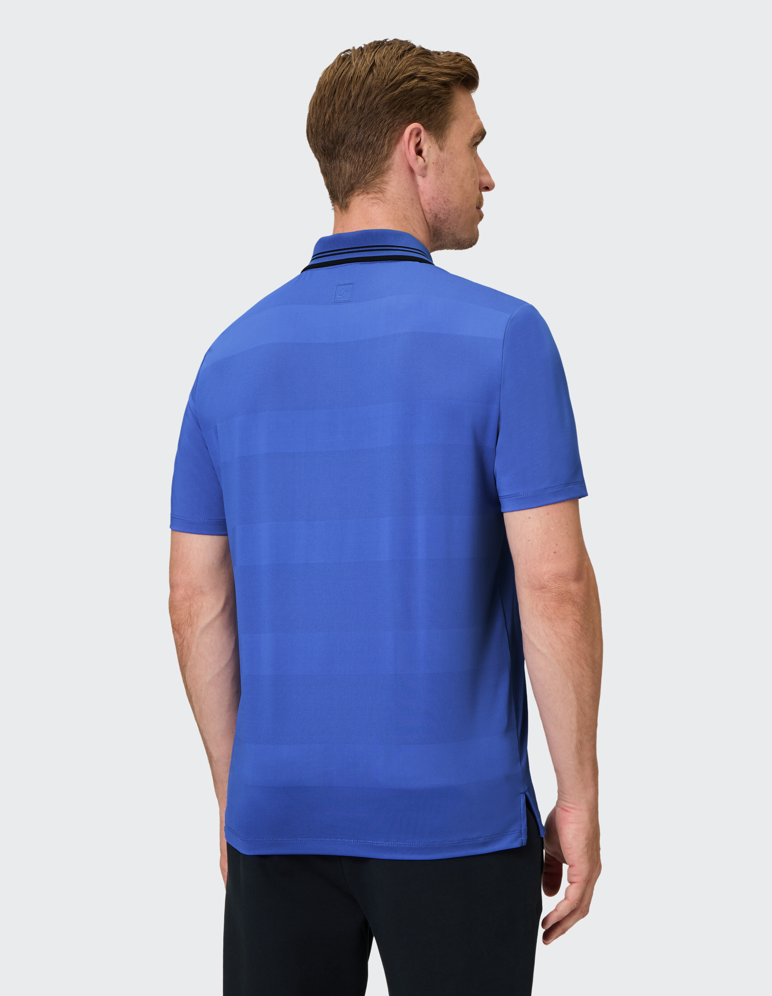 Mann trägt ein blau gestreiftes Freizeit-Poloshirt für einen bequemen, stilvollen Look.