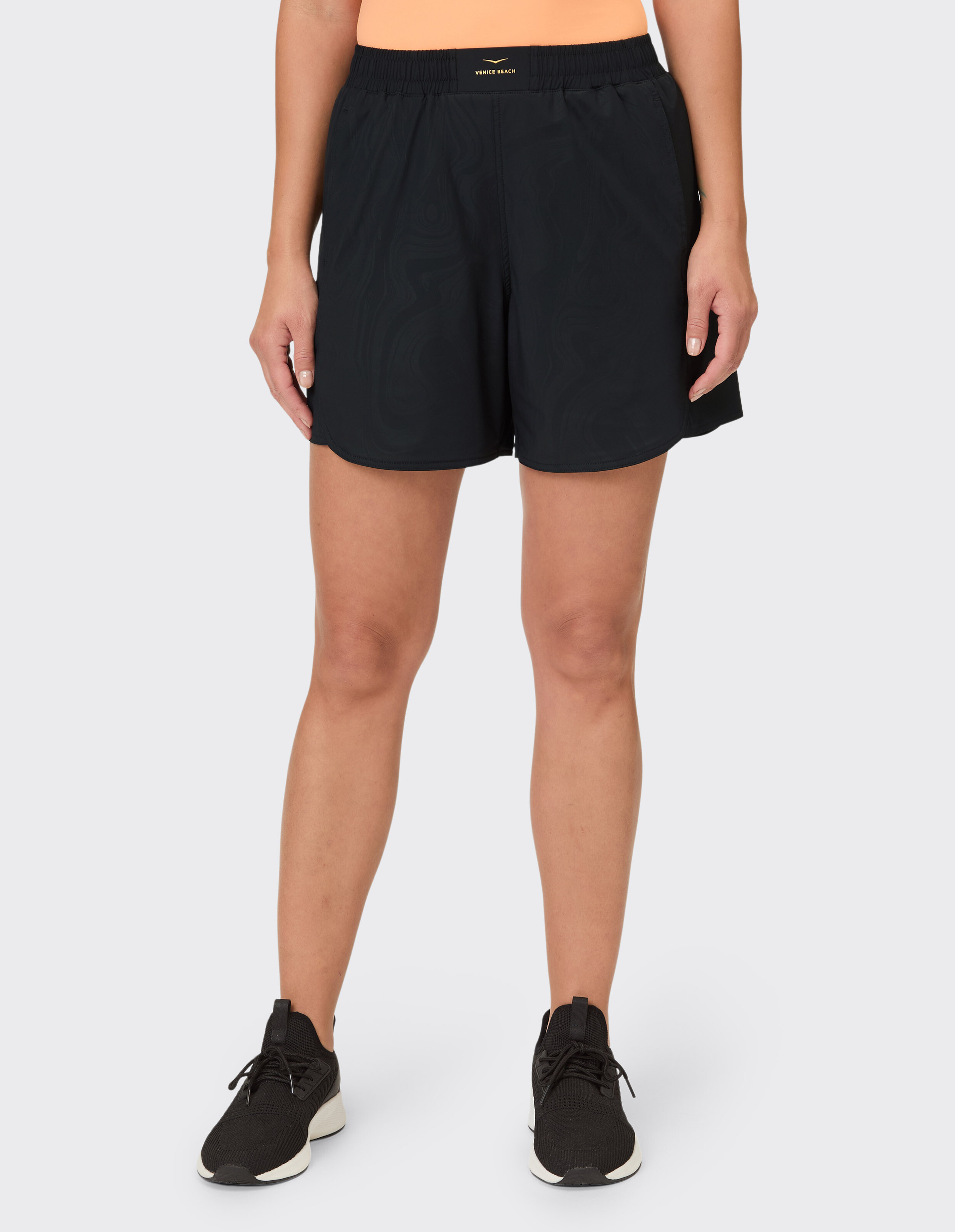 Frau trägt schwarze Sportshorts mit elastischem Bund für Freizeitkleidung.