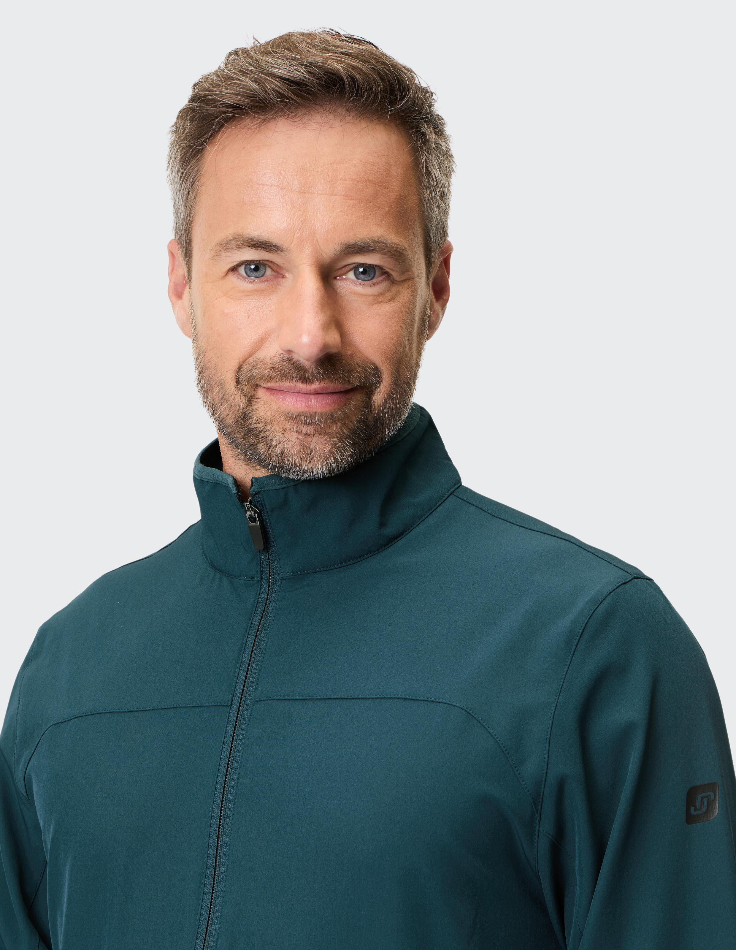 Mann trägt eine dunkelgrüne Freizeitjacke mit Reißverschluss für einen bequemen, eleganten Look.