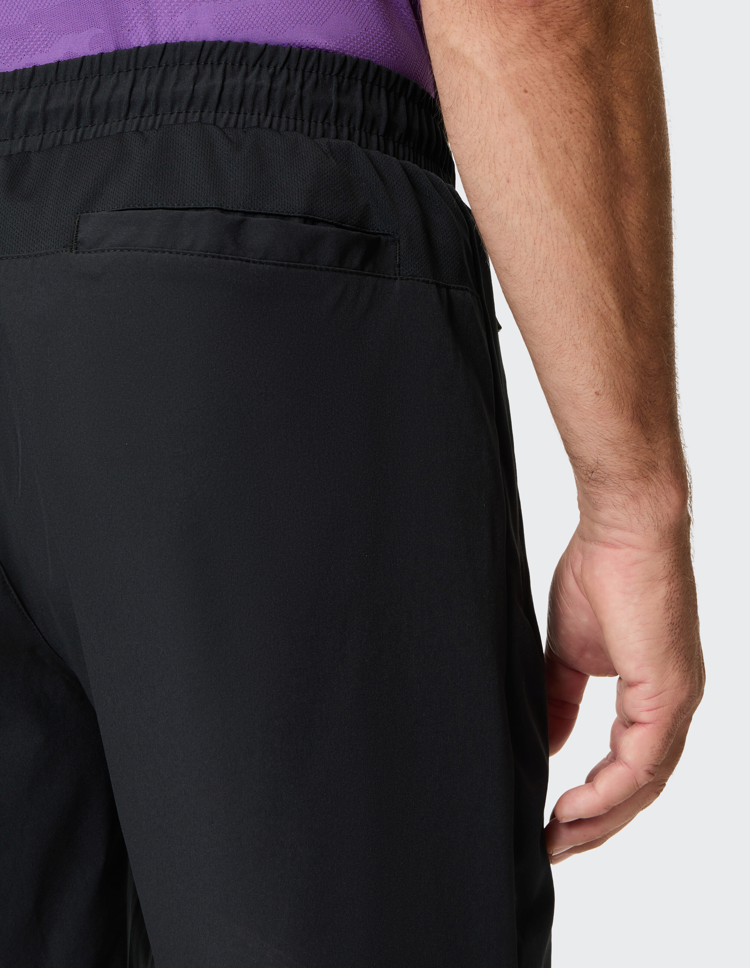 Nahaufnahme der Hand eines Mannes auf schwarzen Freizeitshorts mit elastischem Bund.