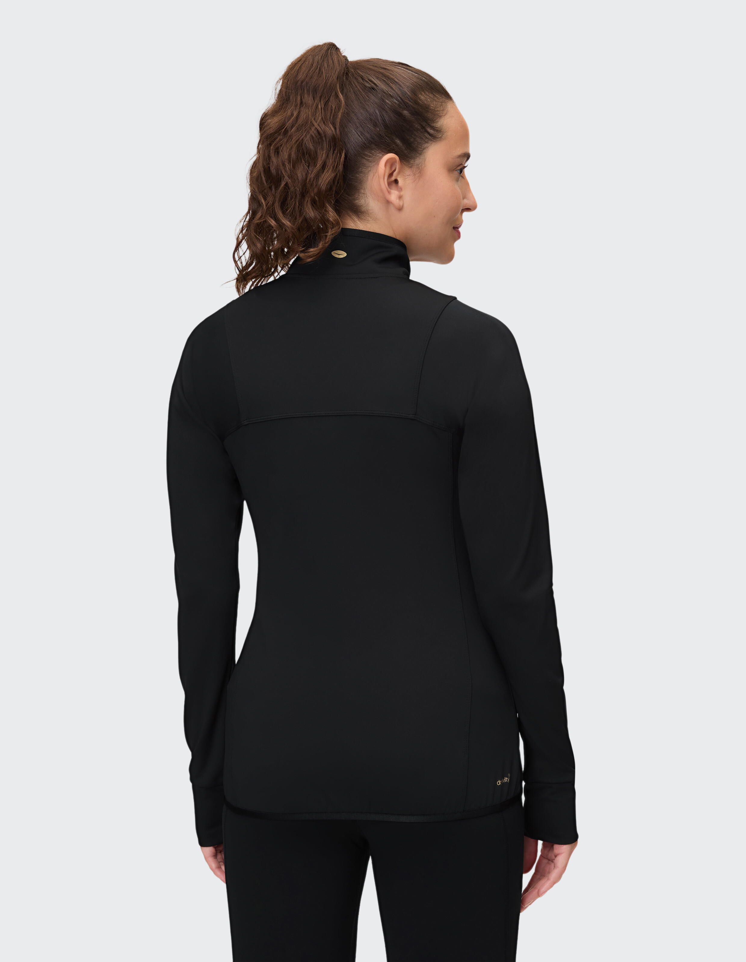 Frau trägt eine schwarze Langarmjacke mit Reißverschluss, perfekt für entspannte Reisen oder zum Faulenzen.