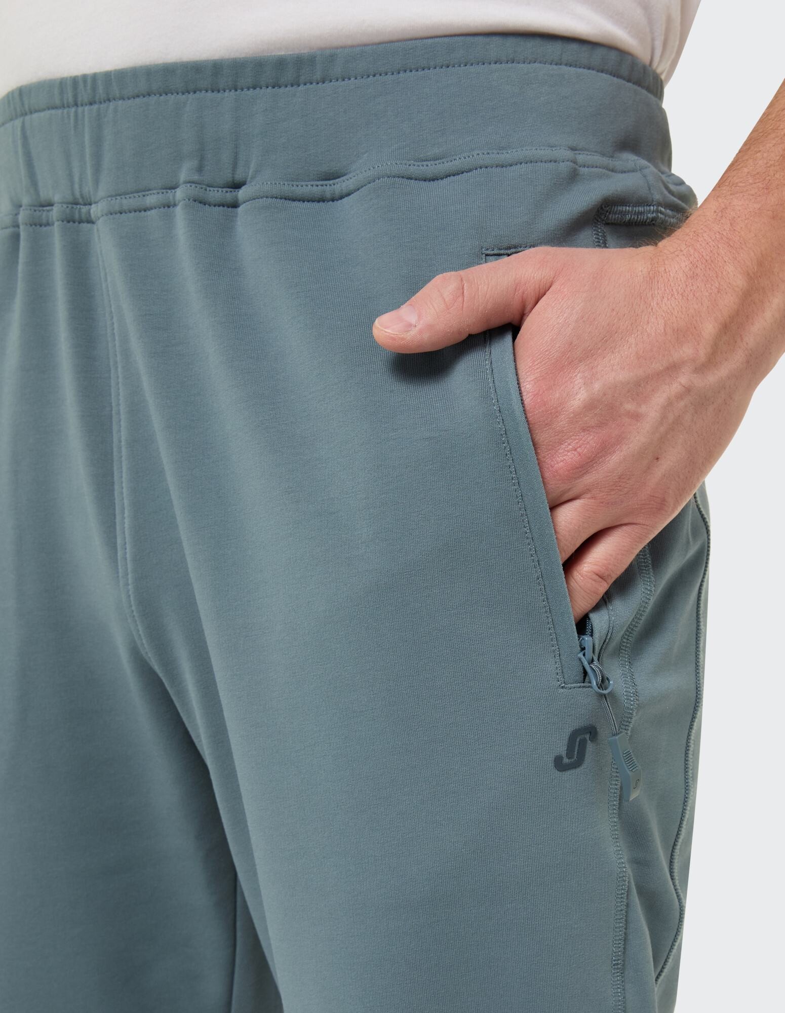 Nahaufnahme einer hellblauen Herren-Jogginghose mit Seitentasche und Logo.