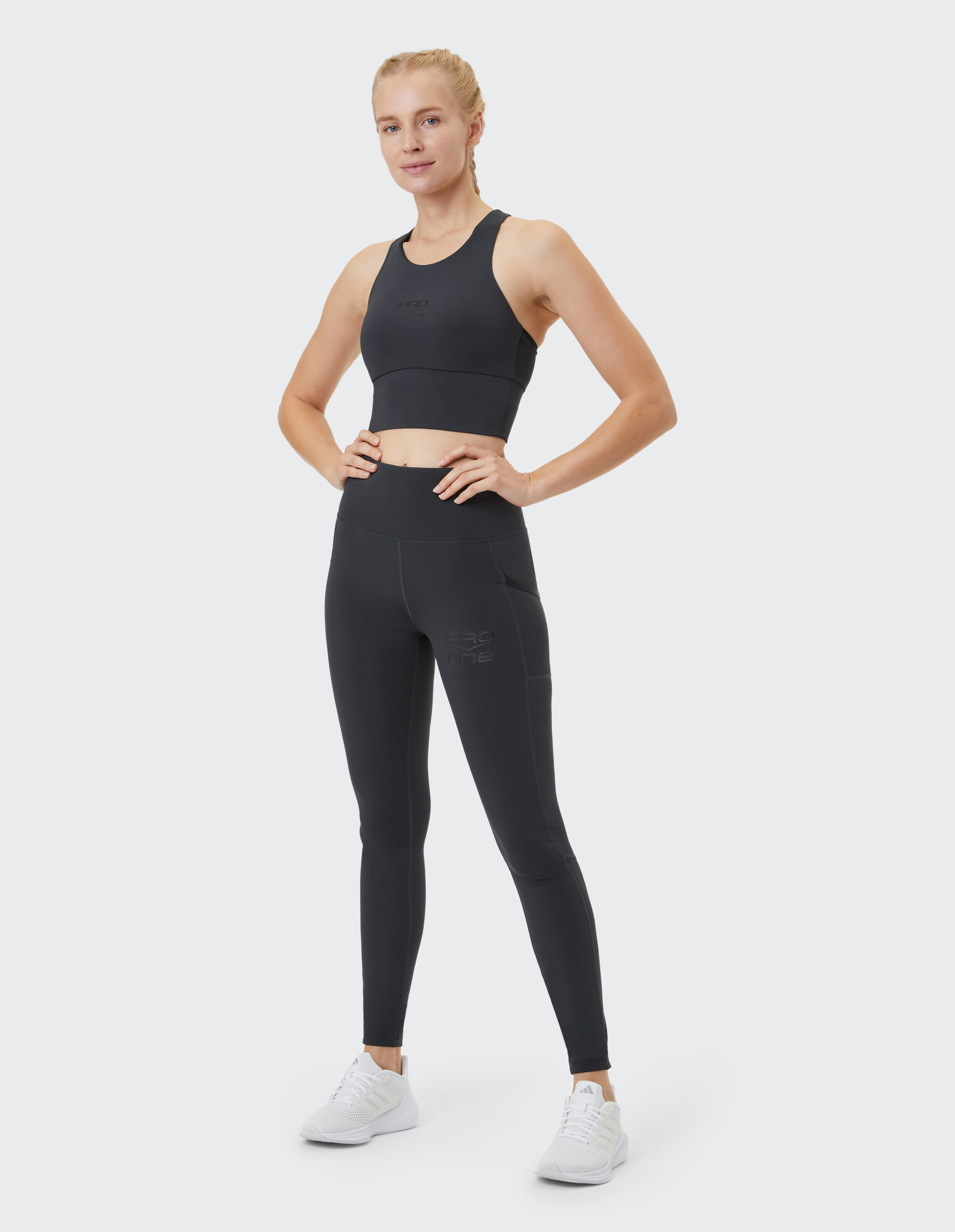 Frau trägt schwarze Sportstrumpfhosen von Venice Beach Colorado Springs und ein passendes bauchfreies Top.