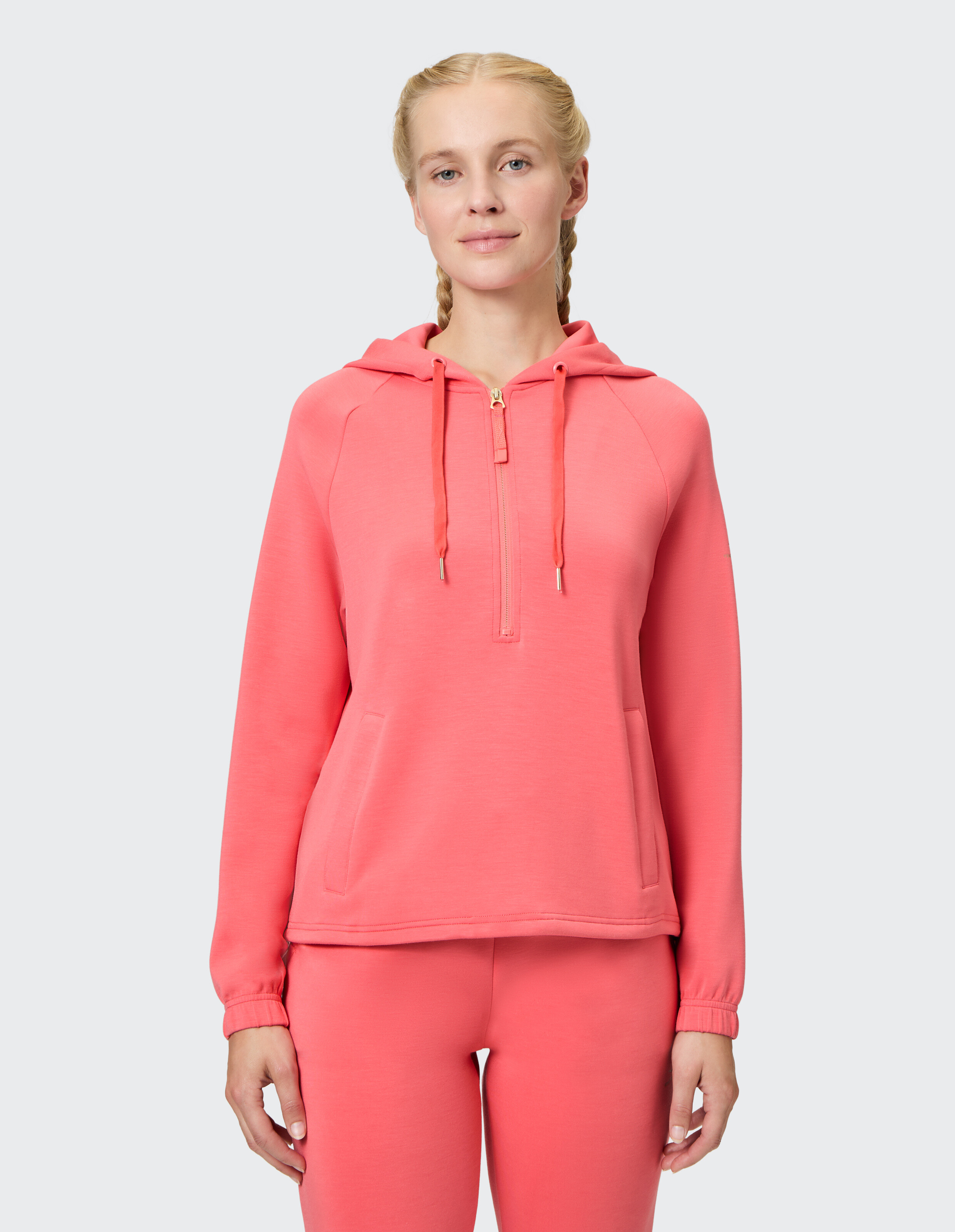 Kuscheliger rosafarbener Kapuzenpullover mit Reißverschluss und Taschen, perfekt für Freizeitkleidung und zum Faulenzen.