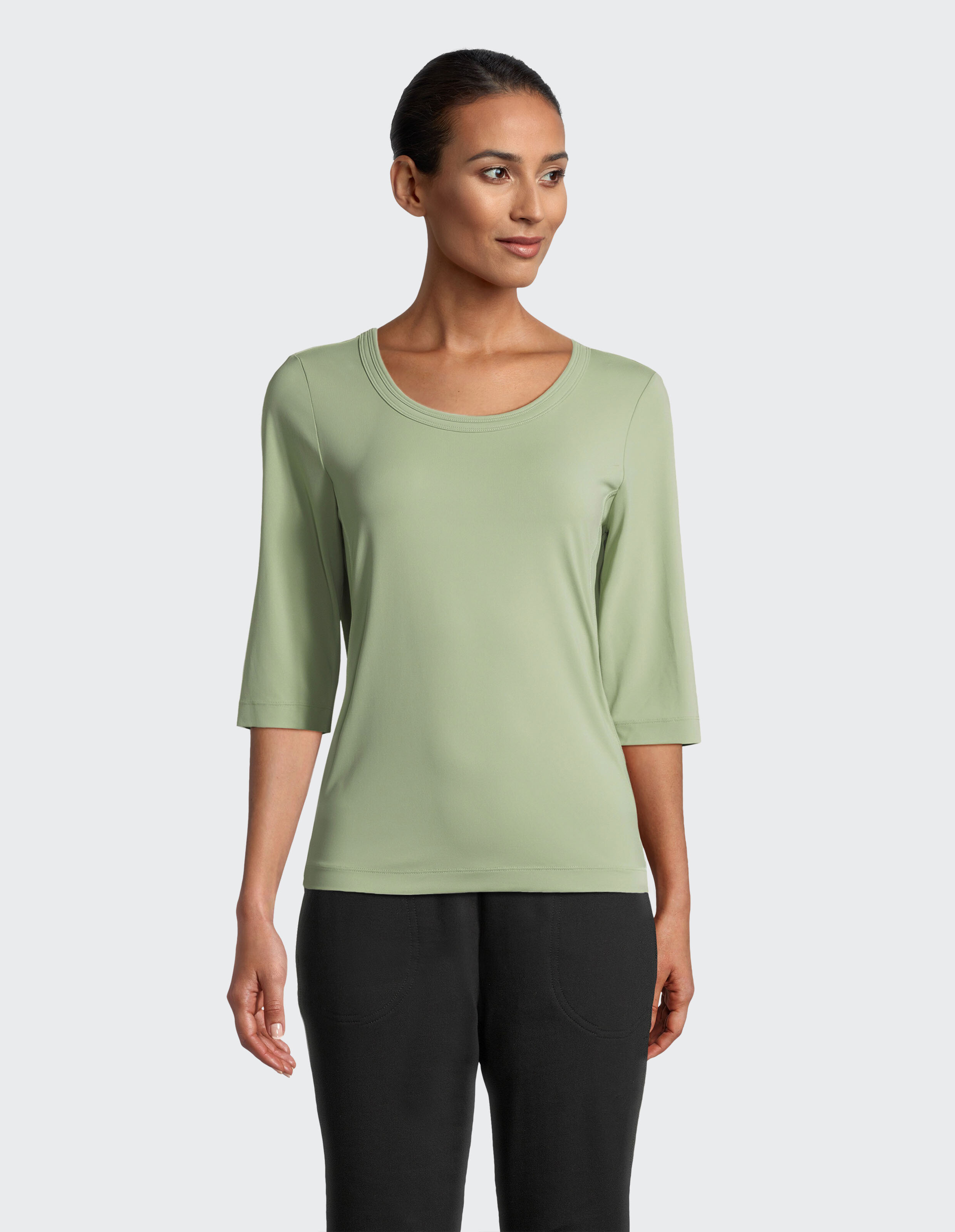 Hellgrünes Damen-Shirt mit Rundhalsausschnitt und dreiviertellangen Ärmeln, schlichter Schnitt, aus leichtem, elastischem Stoff.