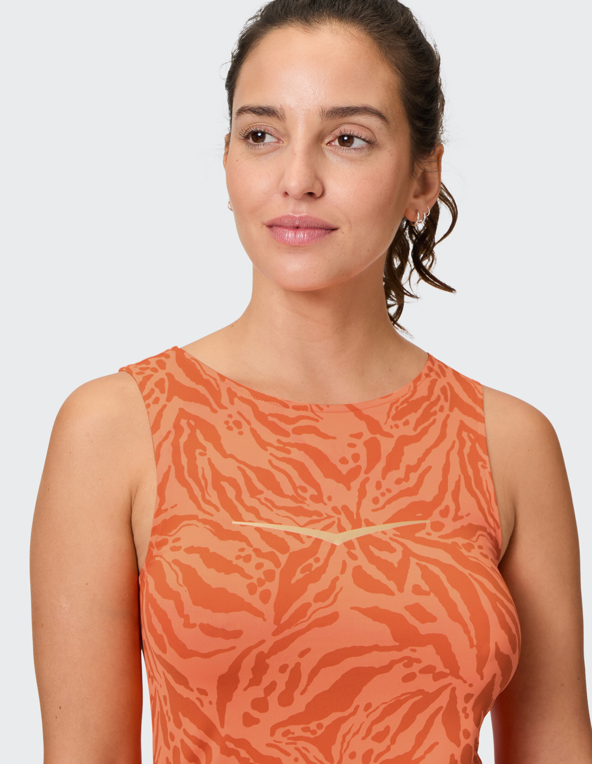 Frau trägt ein orangefarbenes Venice Beach Tanktop Enny mit stylischem Animal-Print-Muster.