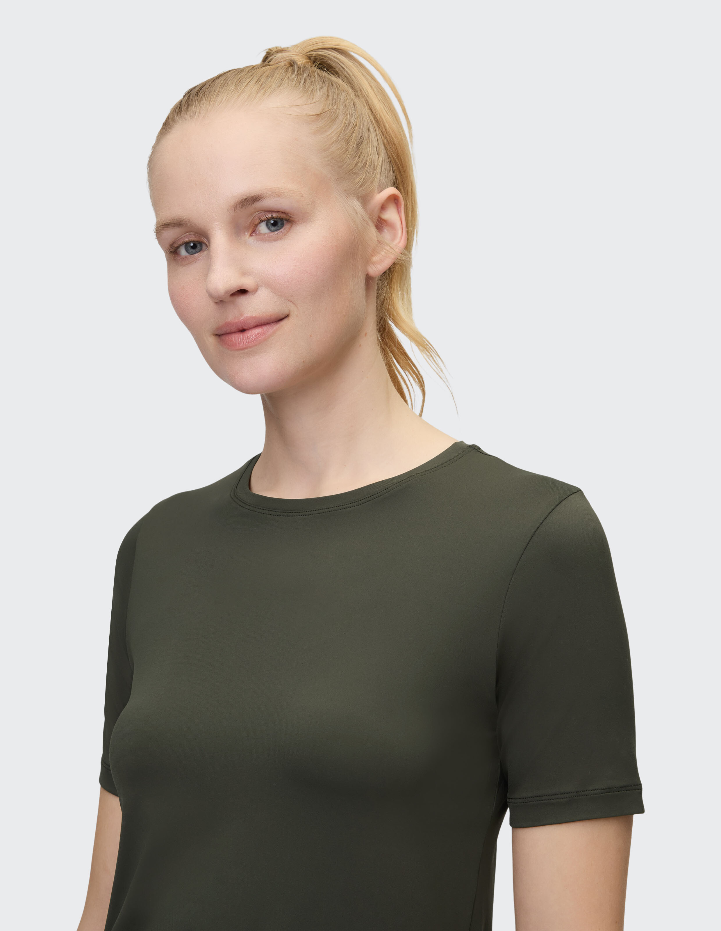 Frau trägt ein lässiges olivgrünes Kurzarm-T-Shirt für alltäglichen Komfort.