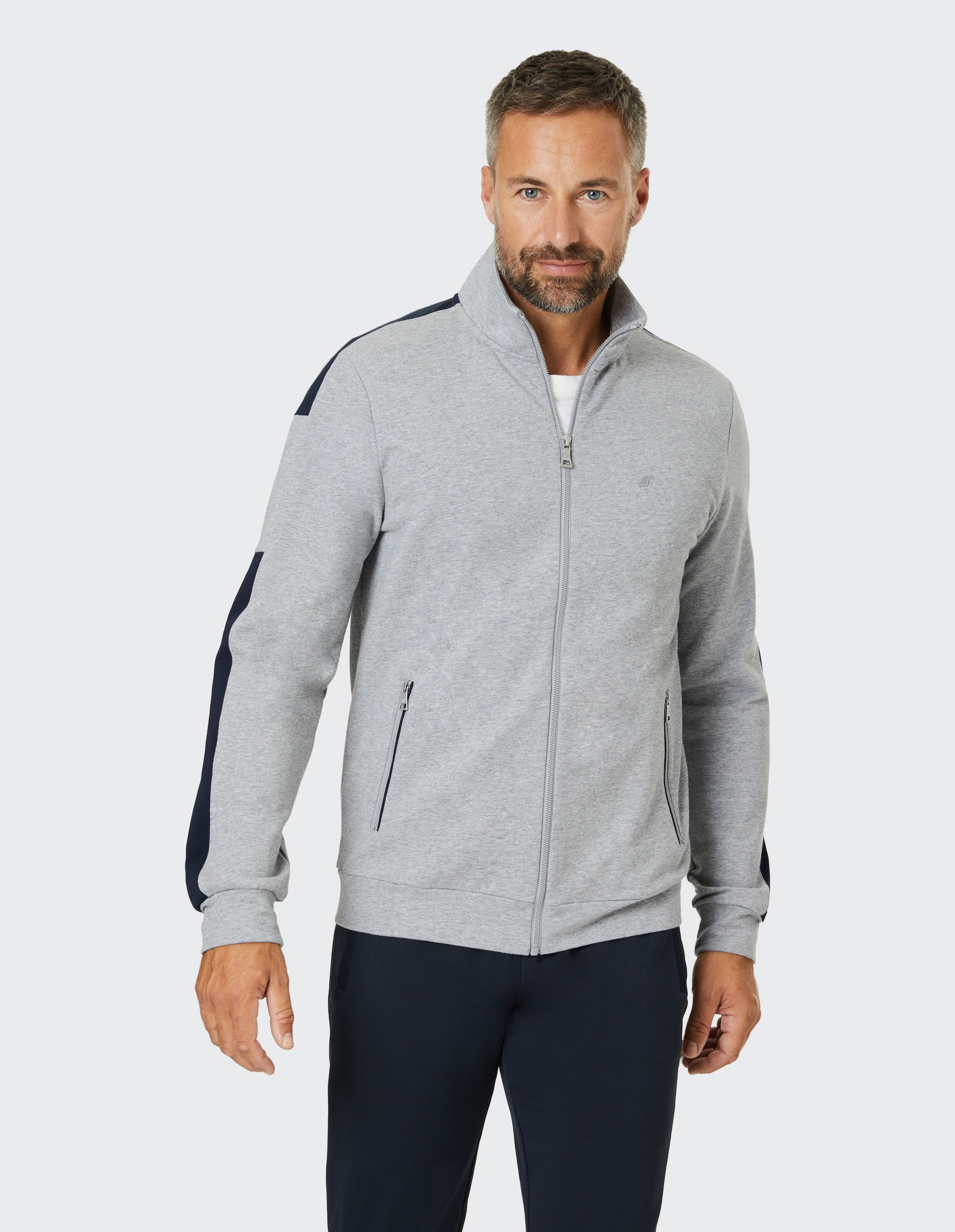 Graue Sweatjacke mit Stehkragen, durchgehendem Reißverschluss, zwei seitlichen Taschen und blauen Streifen an den Ärmeln.
