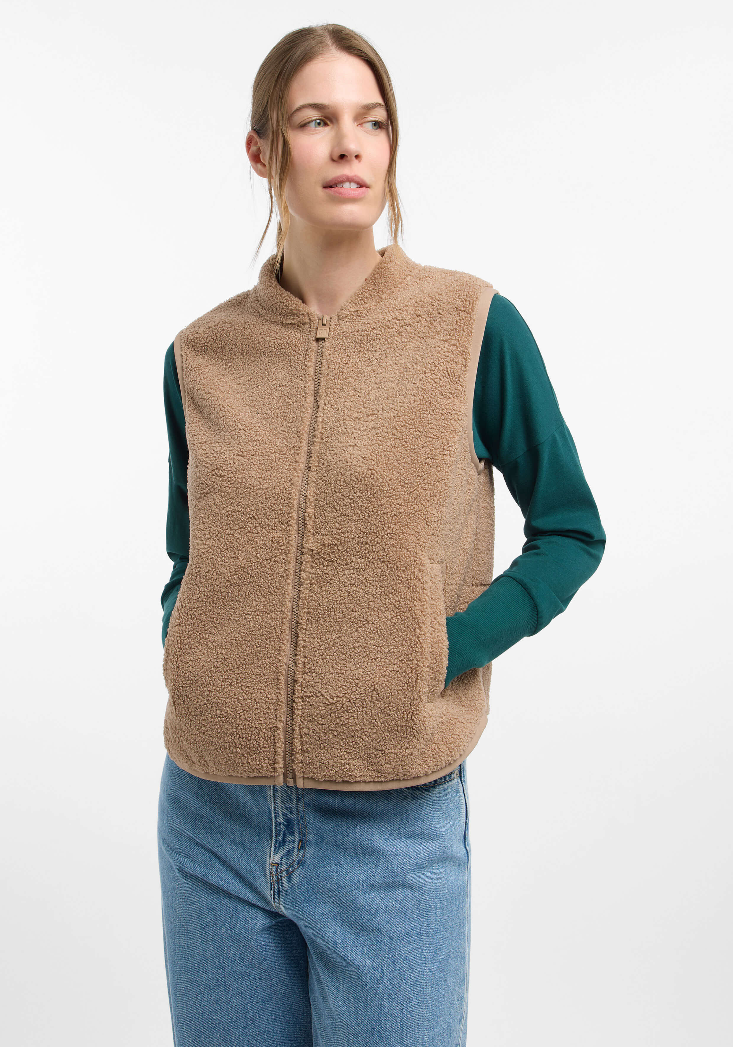 Kuschelige beige Fleeceweste mit Reißverschluss, gepaart mit einem grünen Langarmshirt.