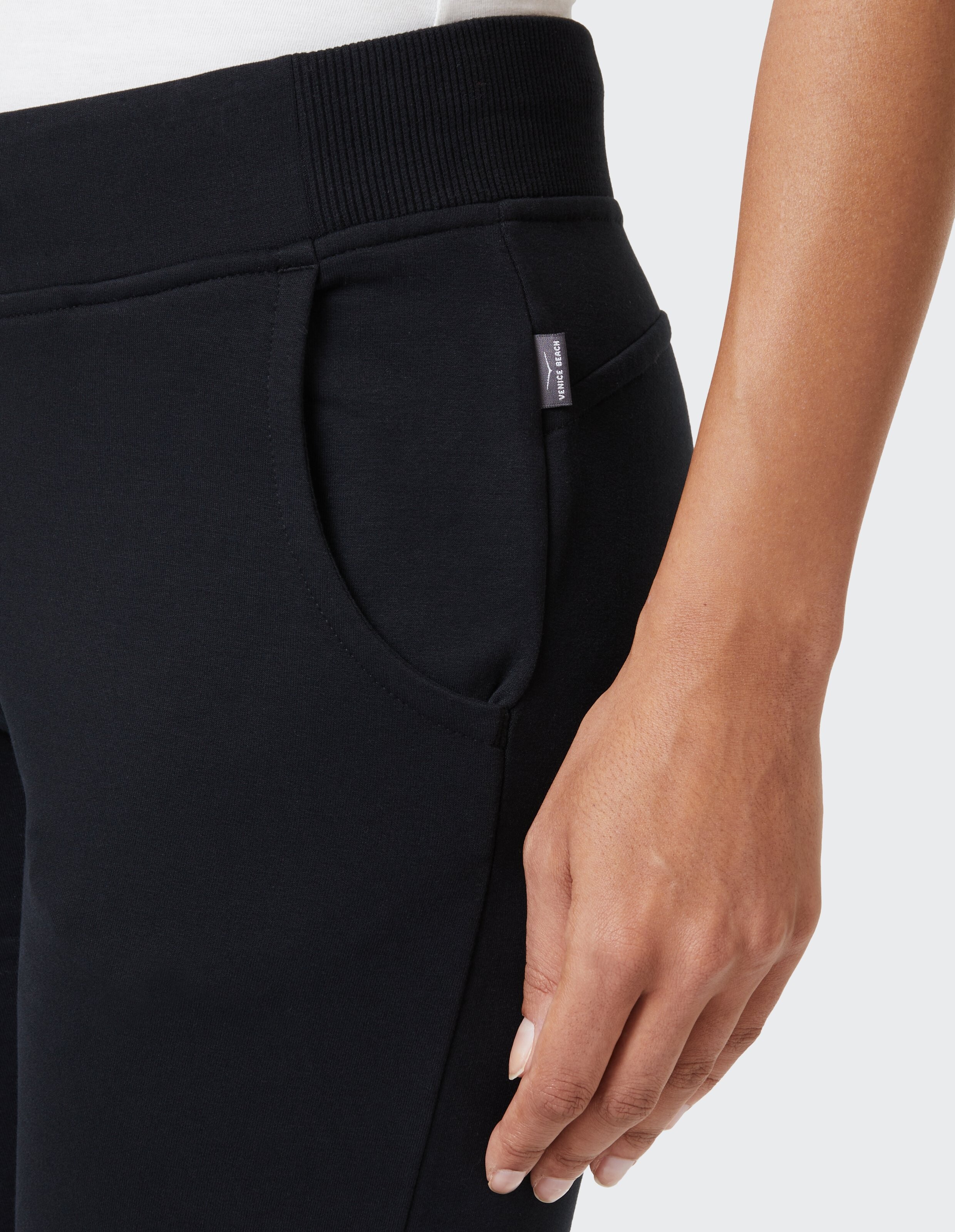 Nahaufnahme einer schwarzen Freizeit-Jogginghose mit geripptem Bund und Seitentasche.