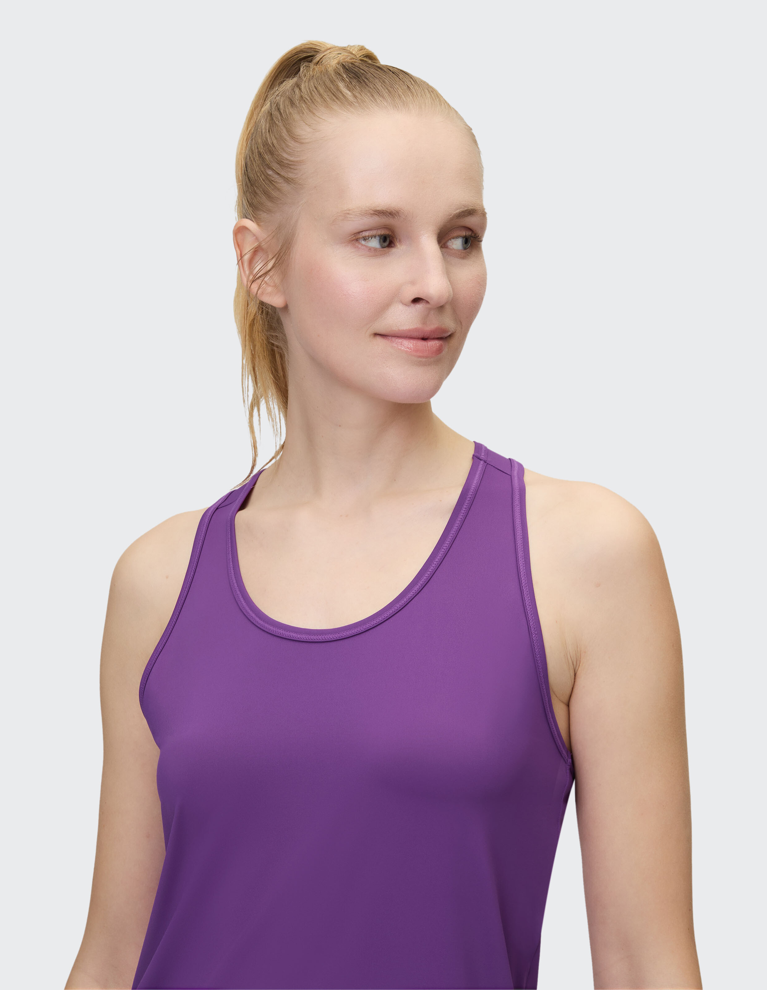 Frau trägt ein ärmelloses lila Tanktop und zeigt einen lässigen und bequemen Stil.