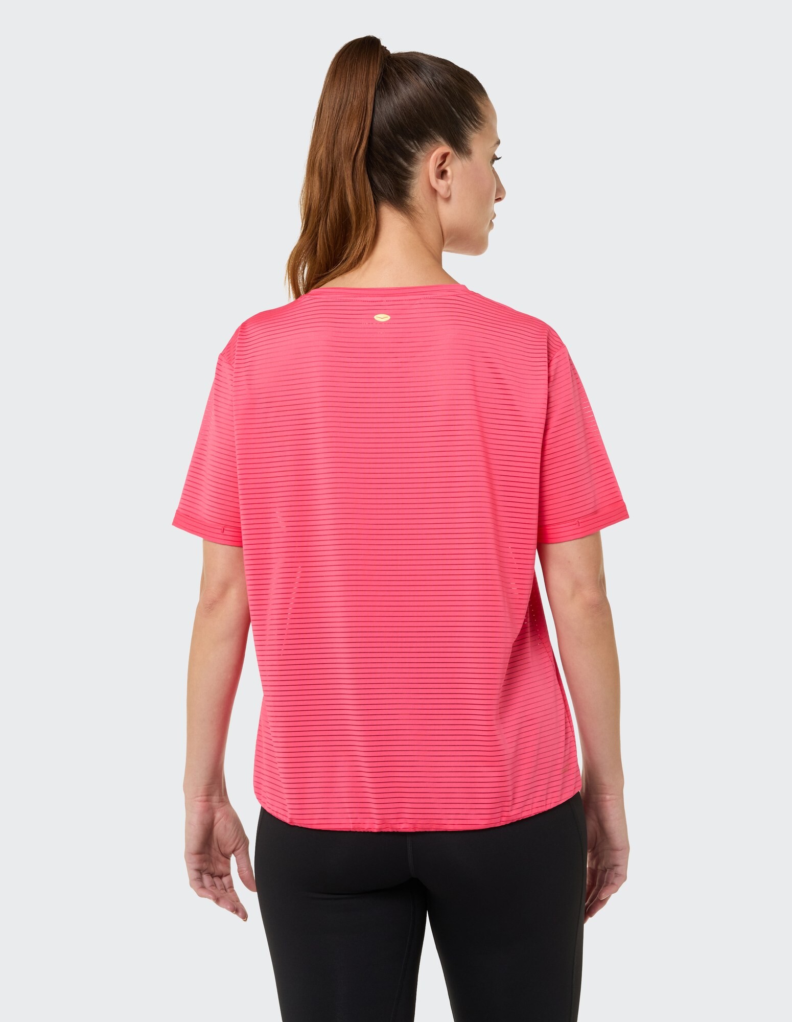 Rückansicht einer Frau in einem rosa gestreiften Freizeit-T-Shirt, perfekt zum Entspannen.