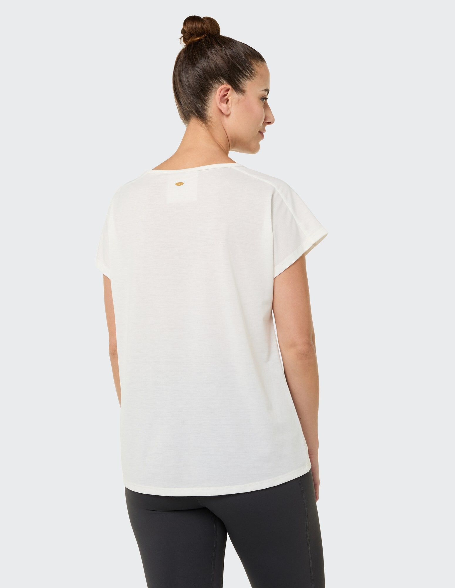 Rückansicht einer Frau in einem weißen Freizeittop, perfekt für entspannte Ausflüge.