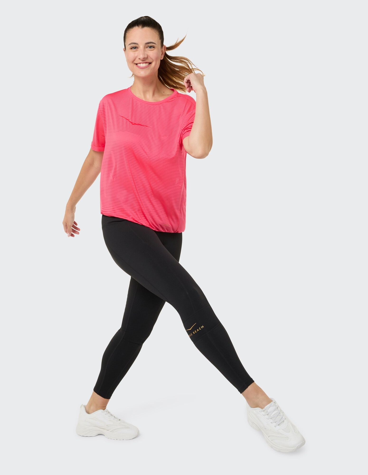 Frau in einem rosa gestreiften T-Shirt und schwarzen Leggings, perfekt für Freizeitkleidung.