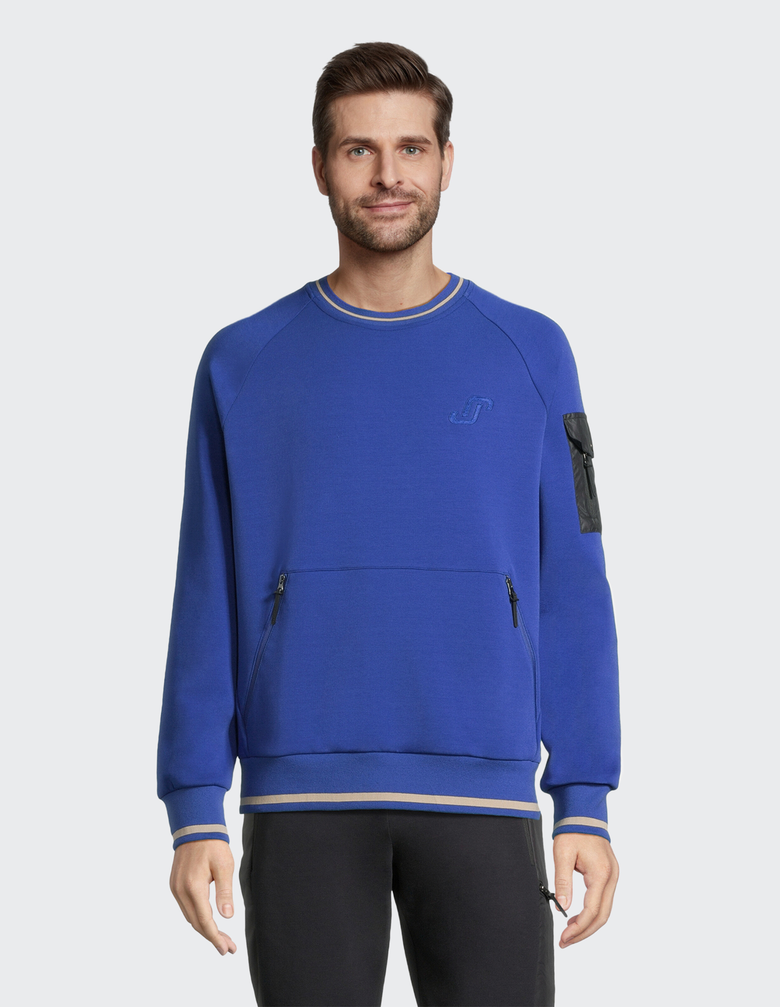 Blauer Sweatshirt mit Rundhals, schwarzer Ärmeltasche und Reißverschlusstaschen, beige Streifen an Bündchen und Saum.