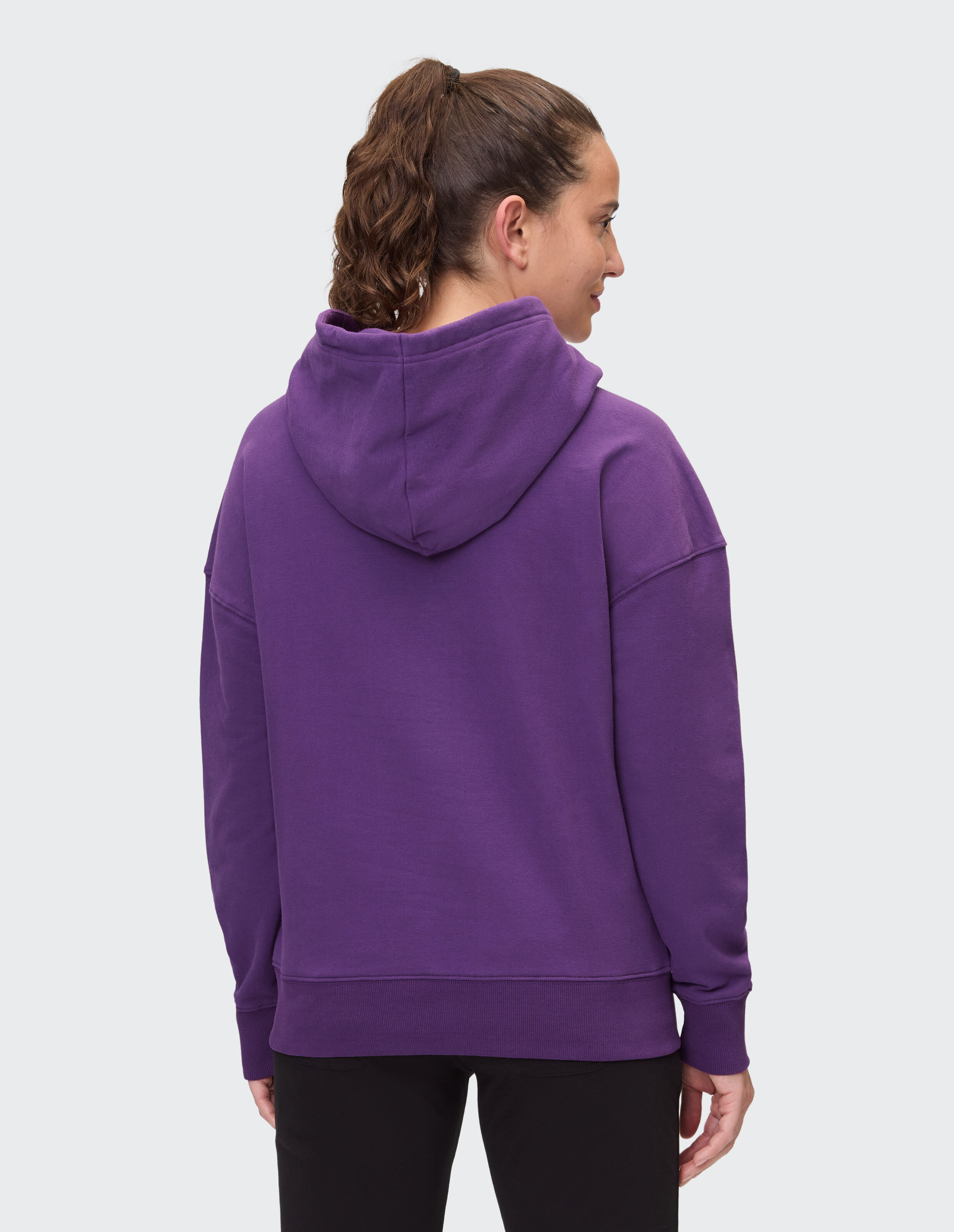 Rückansicht einer Frau in einem kuscheligen lila Kapuzenpullover, perfekt für Freizeitkleidung.