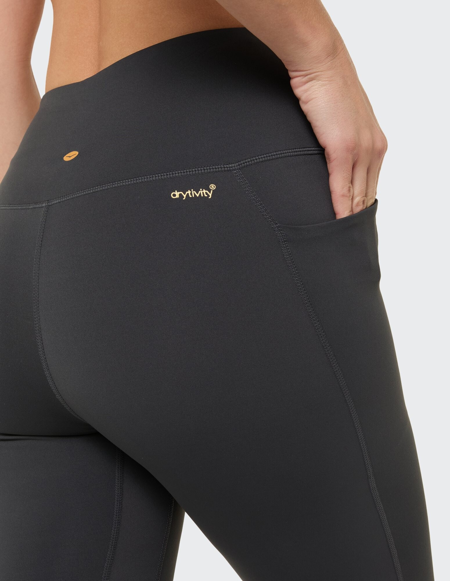 Nahaufnahme einer schwarzen Leggings mit Tasche und drytivity-Logo, ideal für Freizeitkleidung.