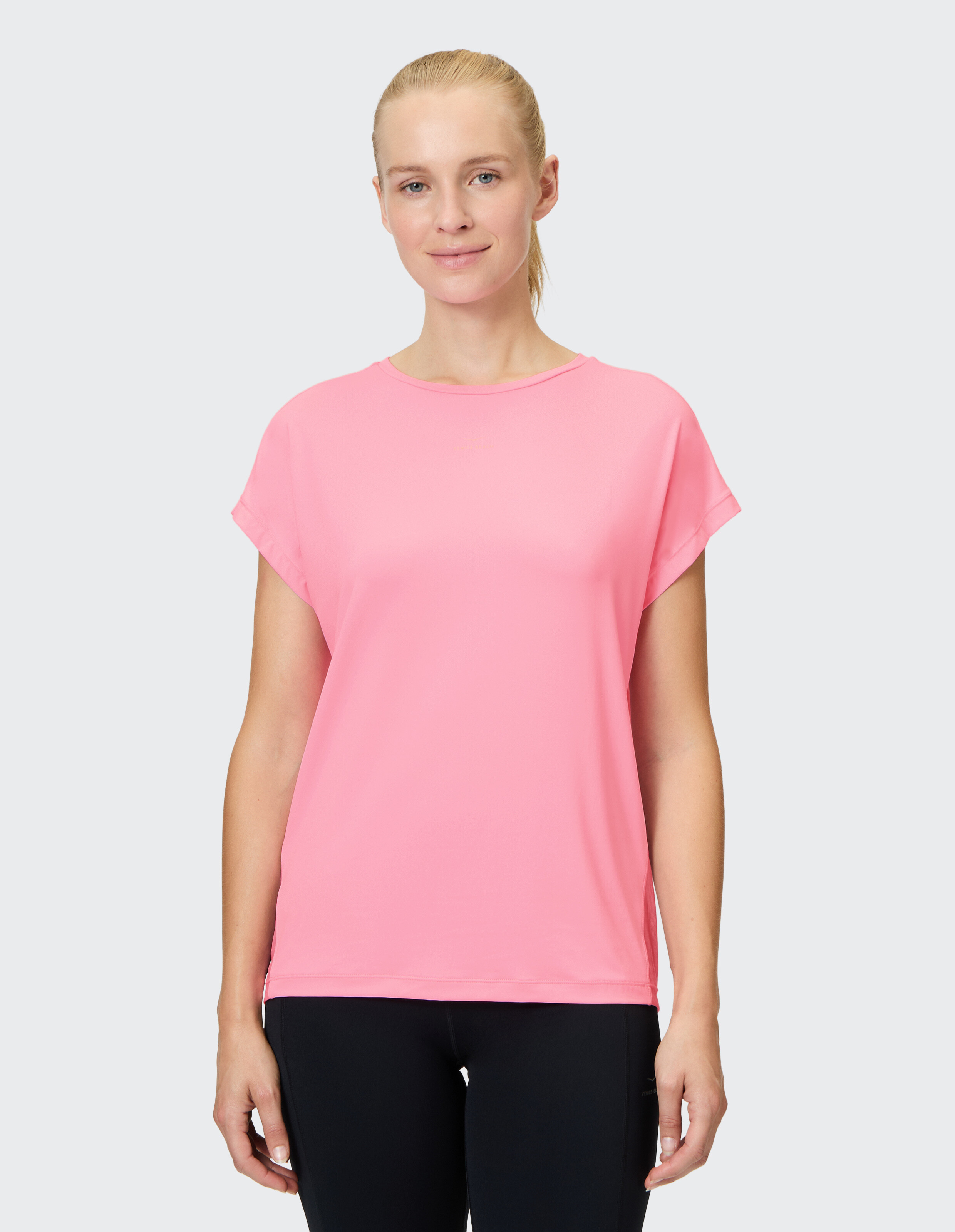 Frau trägt ein rosafarbenes, lässiges Kurzarm-T-Shirt für einen bequemen Alltagsstil.