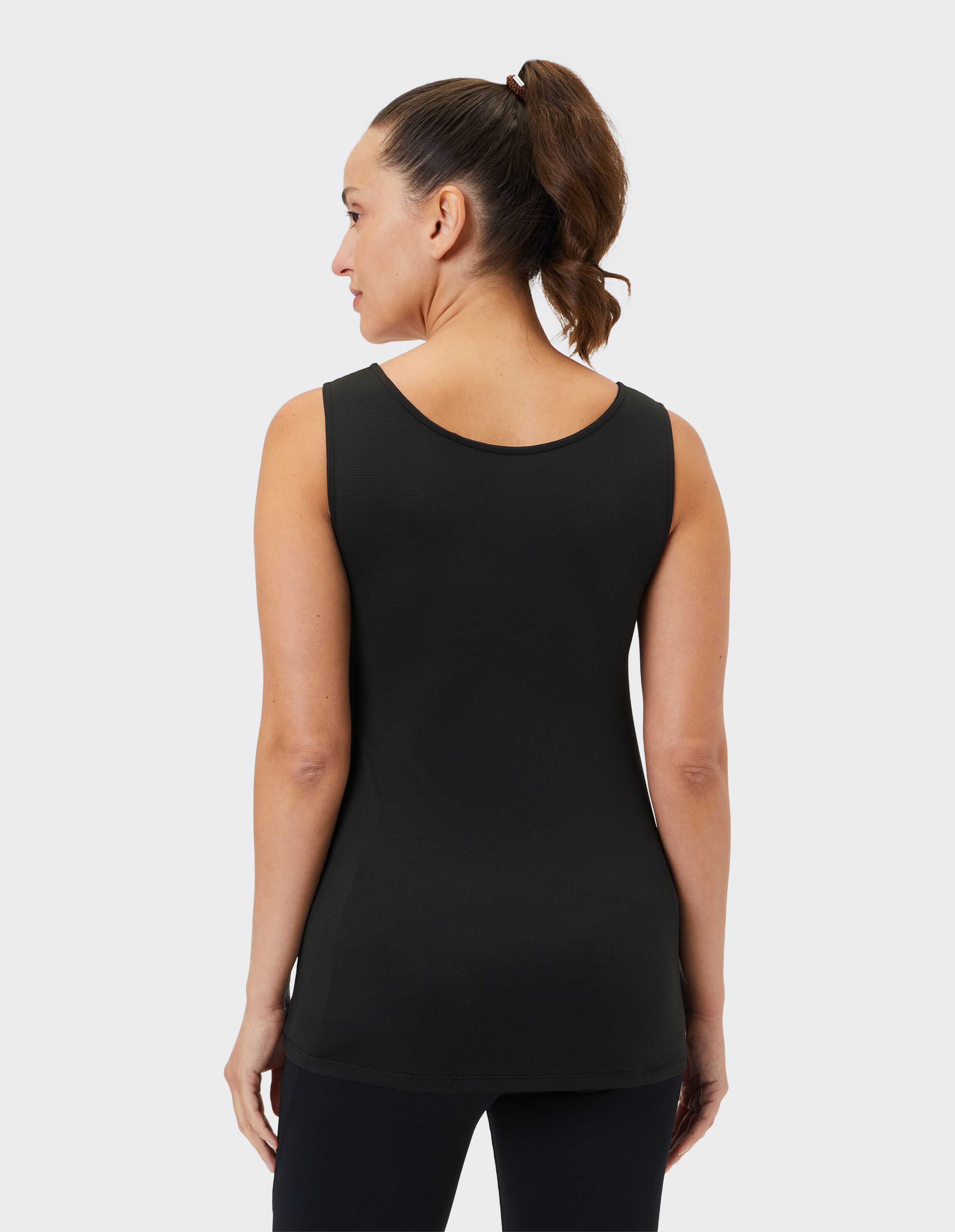 Frau trägt ein schwarzes ärmelloses Tanktop, perfekt für gemütliche Freizeit-Loungewear.