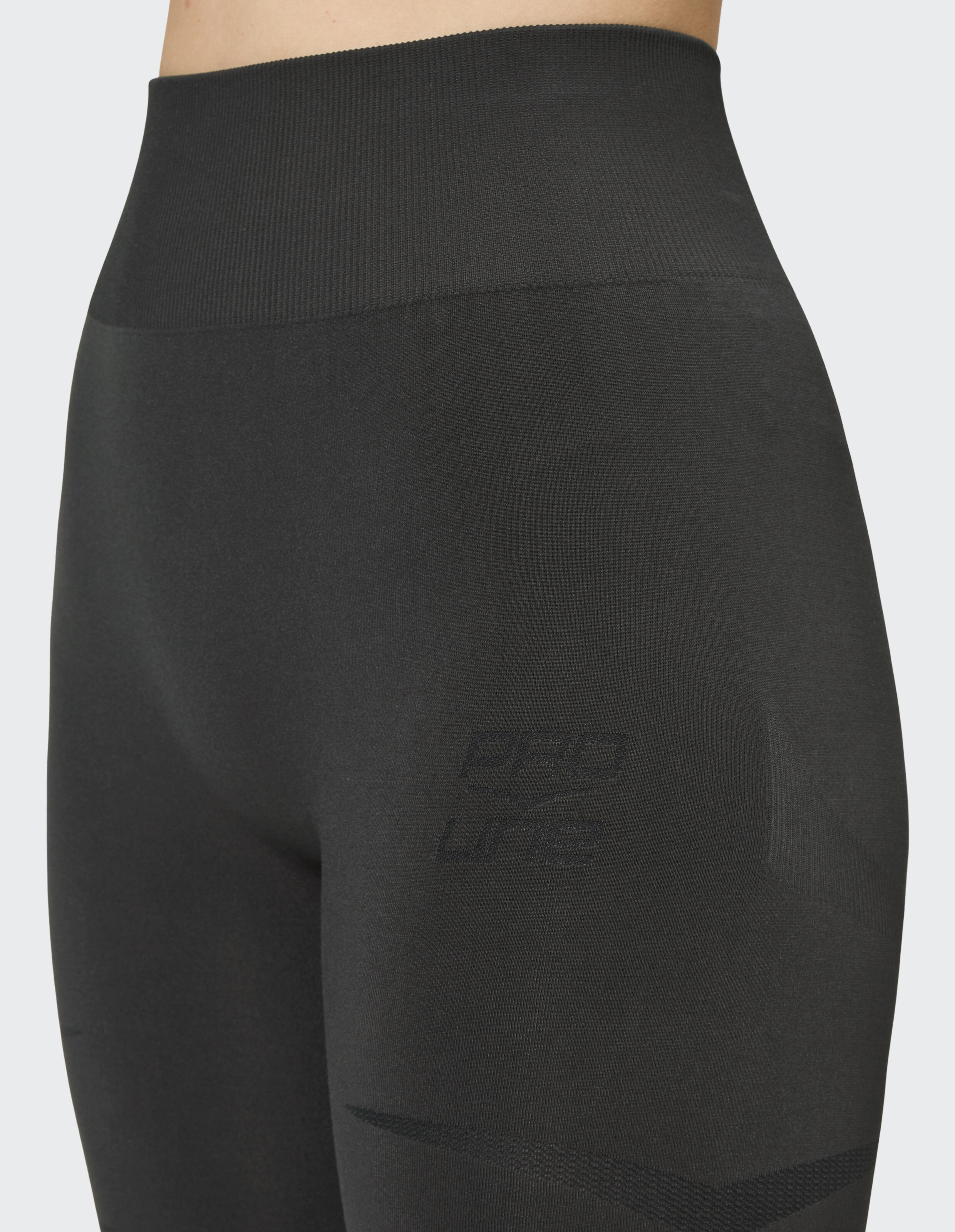 Nahaufnahme einer schwarzen, nahtlosen Leggings mit hoher Taille und dezentem Logo-Detail.