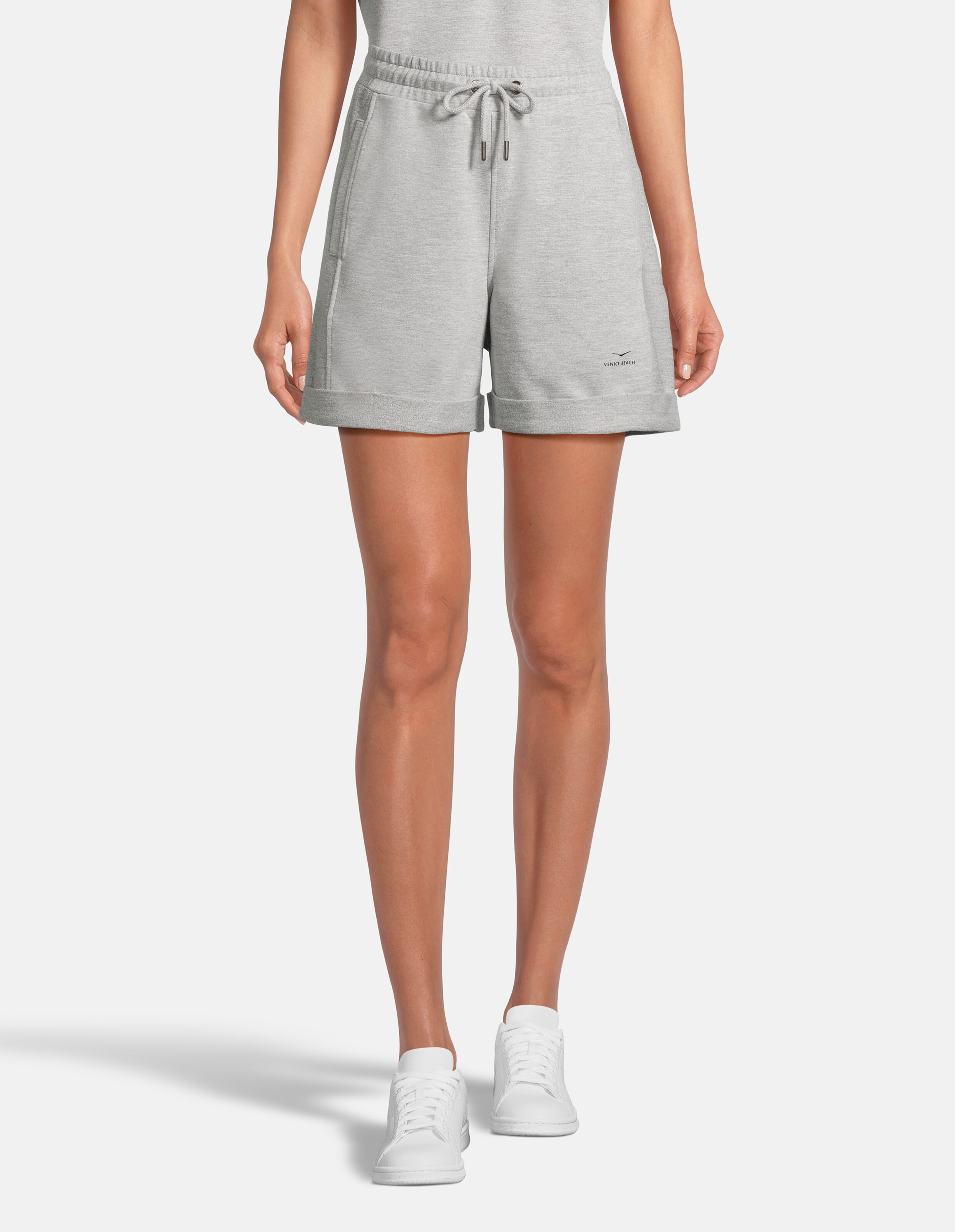 Frau trägt gemütliche, graue, lässige Lounge-Shorts mit Kordelzug in der Taille und Bündchen am Saum.