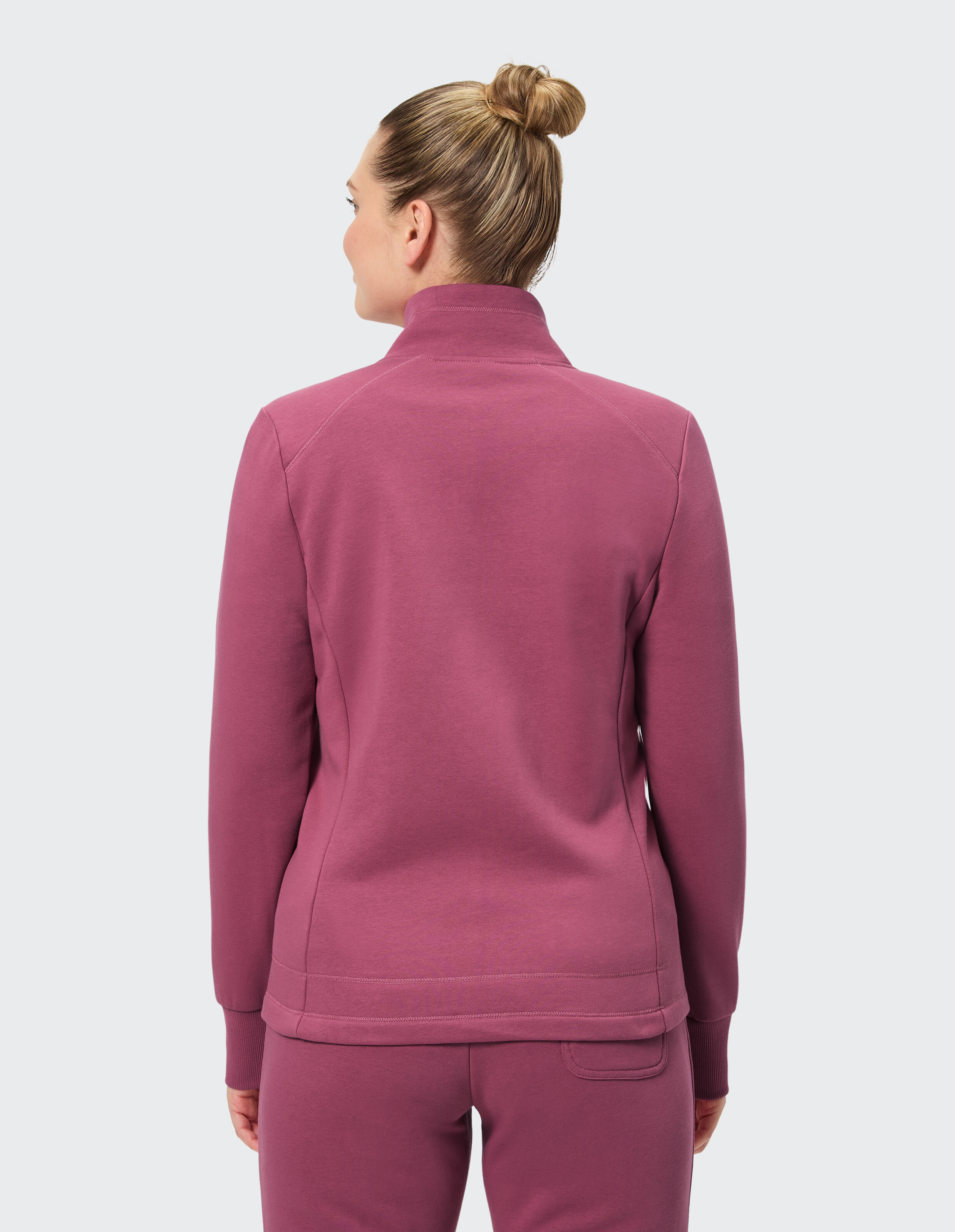 Rückansicht einer Frau in einem gemütlichen lila Sweatshirt mit Reißverschluss, perfekt für Freizeitkleidung.