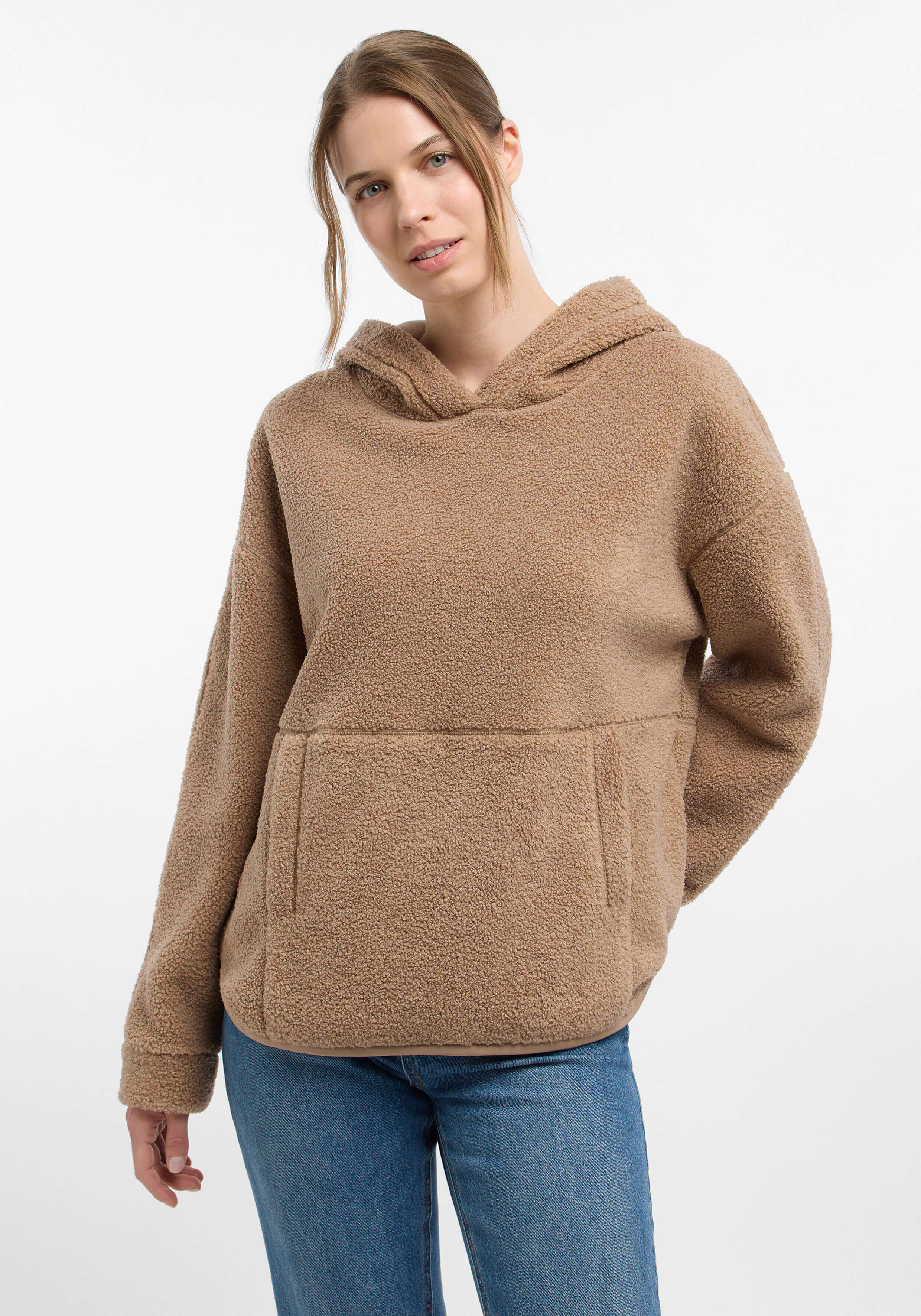 Frau trägt einen kuscheligen beigen Teddyfleece-Hoodie mit Vordertasche für lässigen Stil.