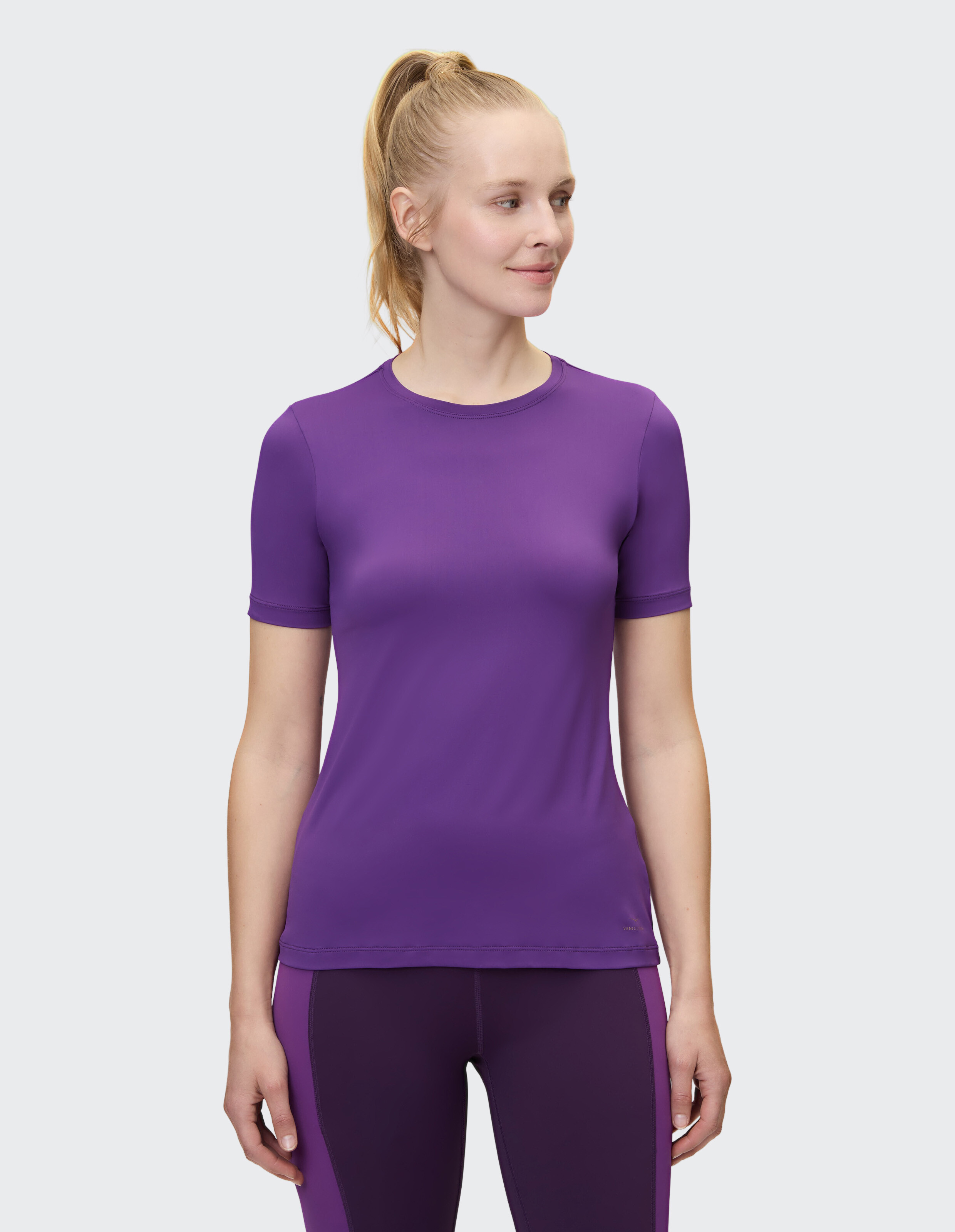 Frau trägt ein lilafarbenes Venice Beach Kurzarmshirt Sia für lässigen, bequemen Stil.