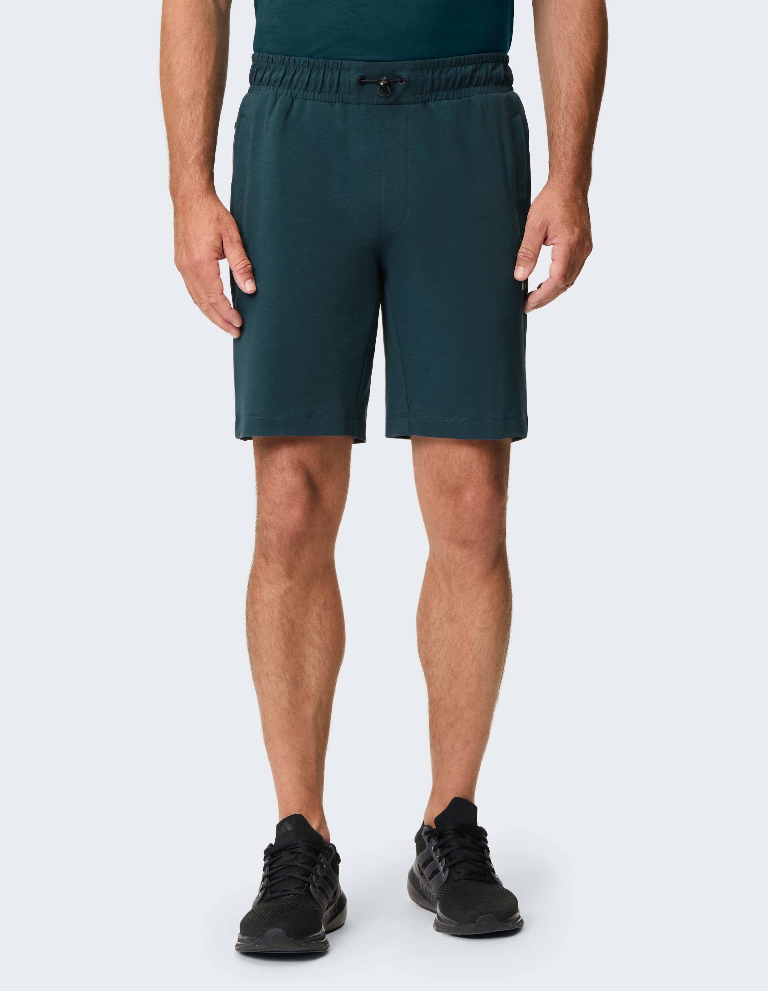 Dunkelgrüne Shorts mit Elastikbund und Kordelzug, schlichtes Design, aus weichem Material mit seitlichen Taschen.