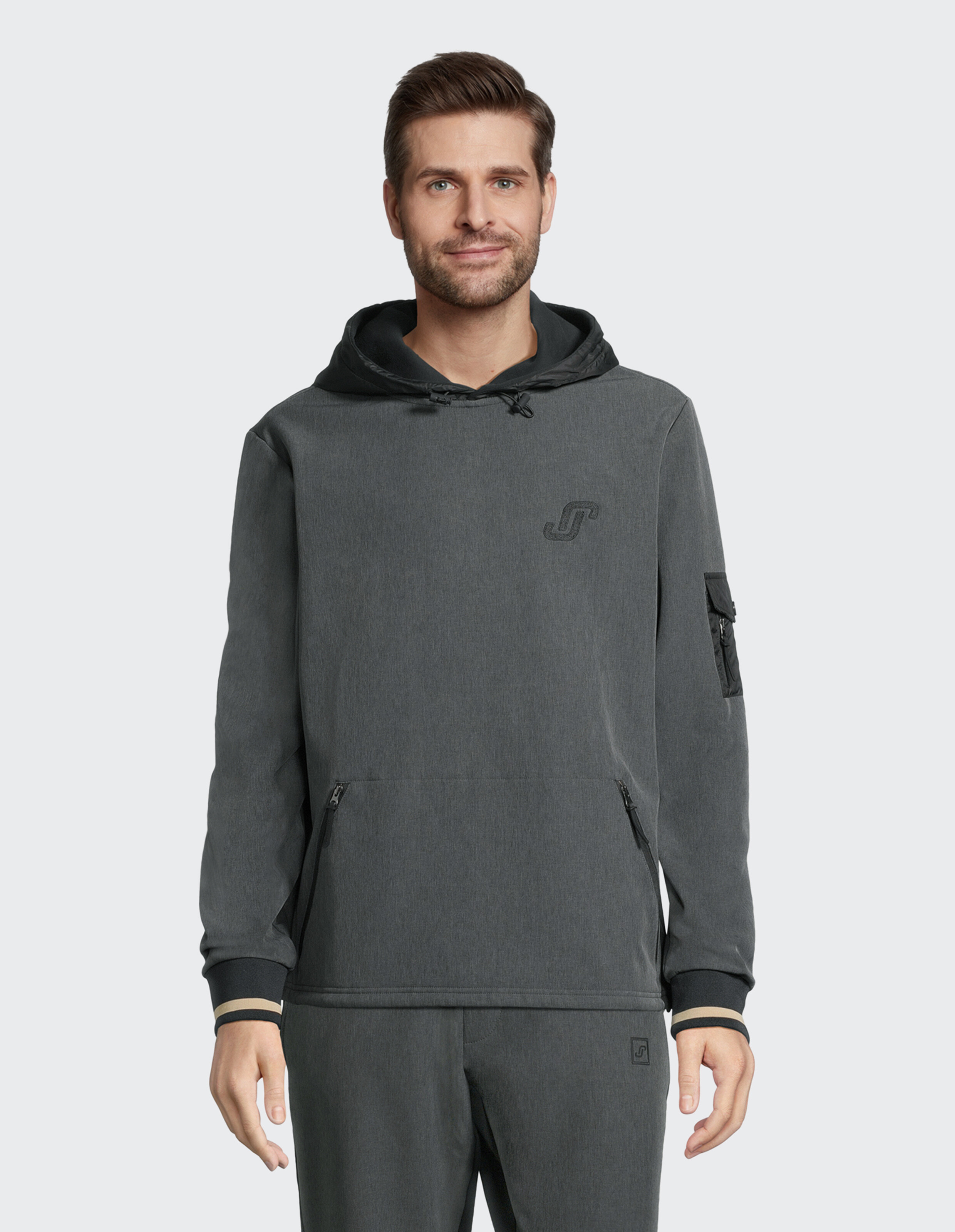 Mann trägt einen gemütlichen, anthrazitfarbenen, lässigen Kapuzenpullover mit Kapuze und Reißverschlusstaschen.