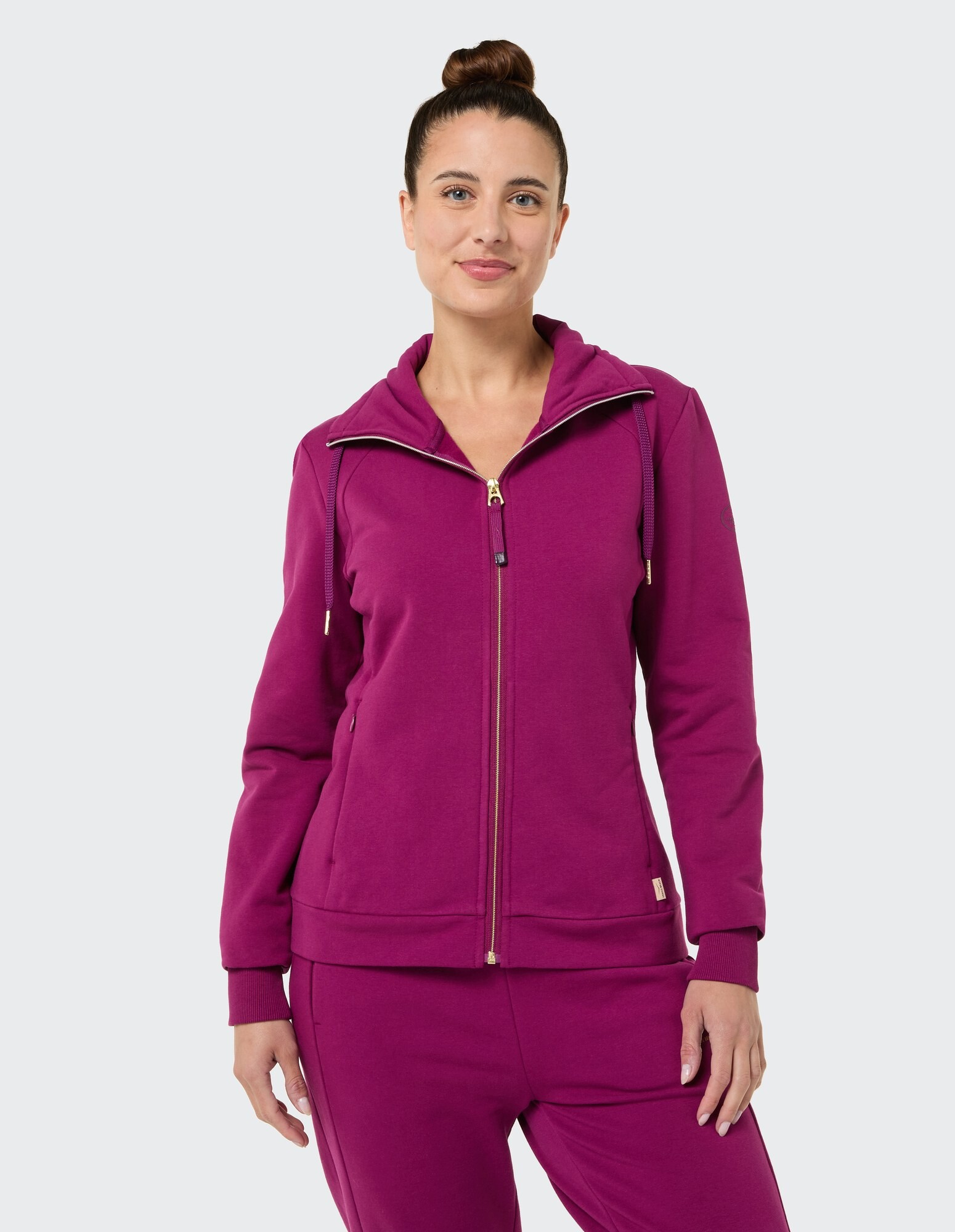 Frau in einem kuscheligen lila Kapuzenpullover mit Reißverschluss, perfekt für Freizeitkleidung oder zum Faulenzen.