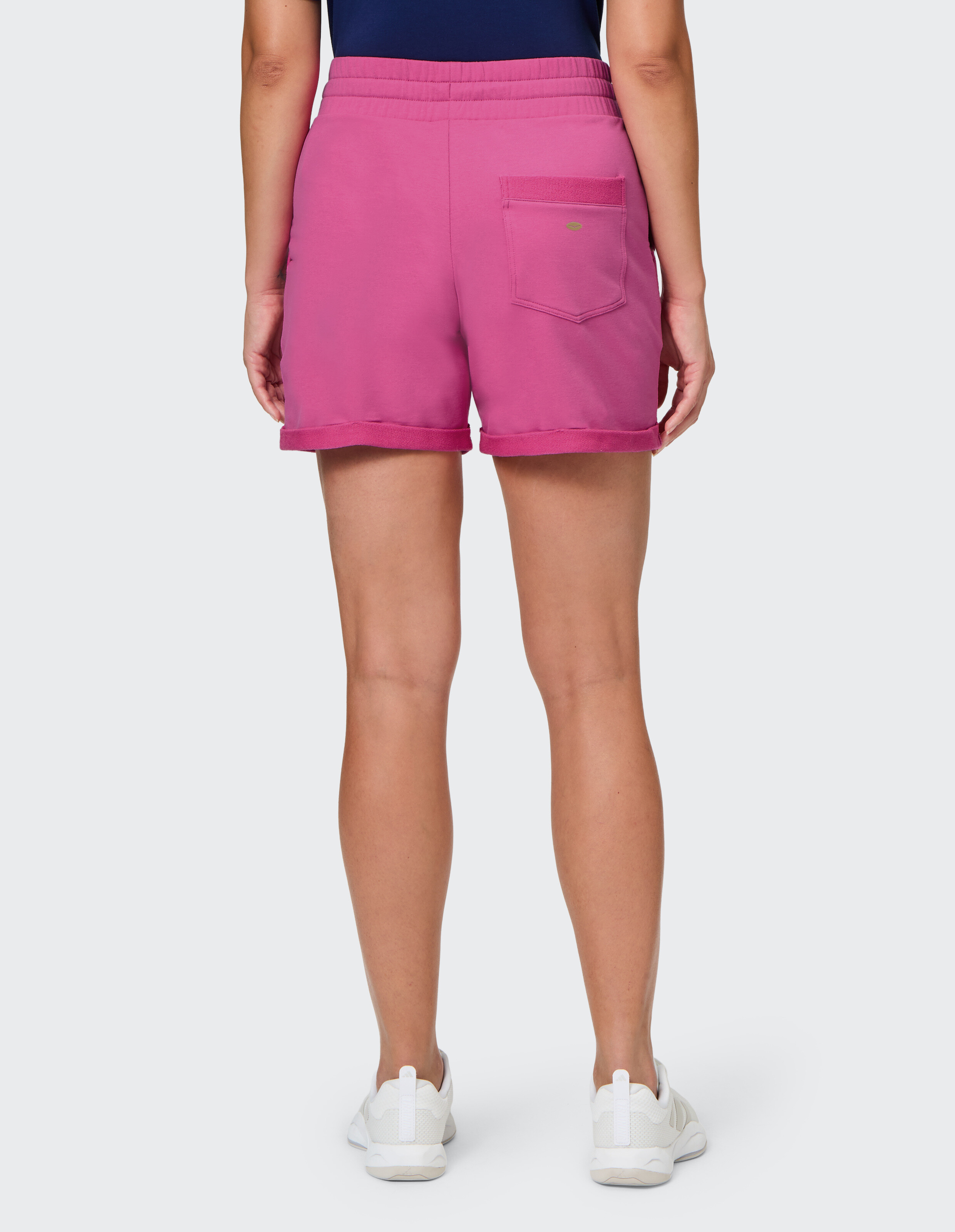 Rückansicht einer Frau, die rosa lässige Shorts mit lockerer Passform trägt.