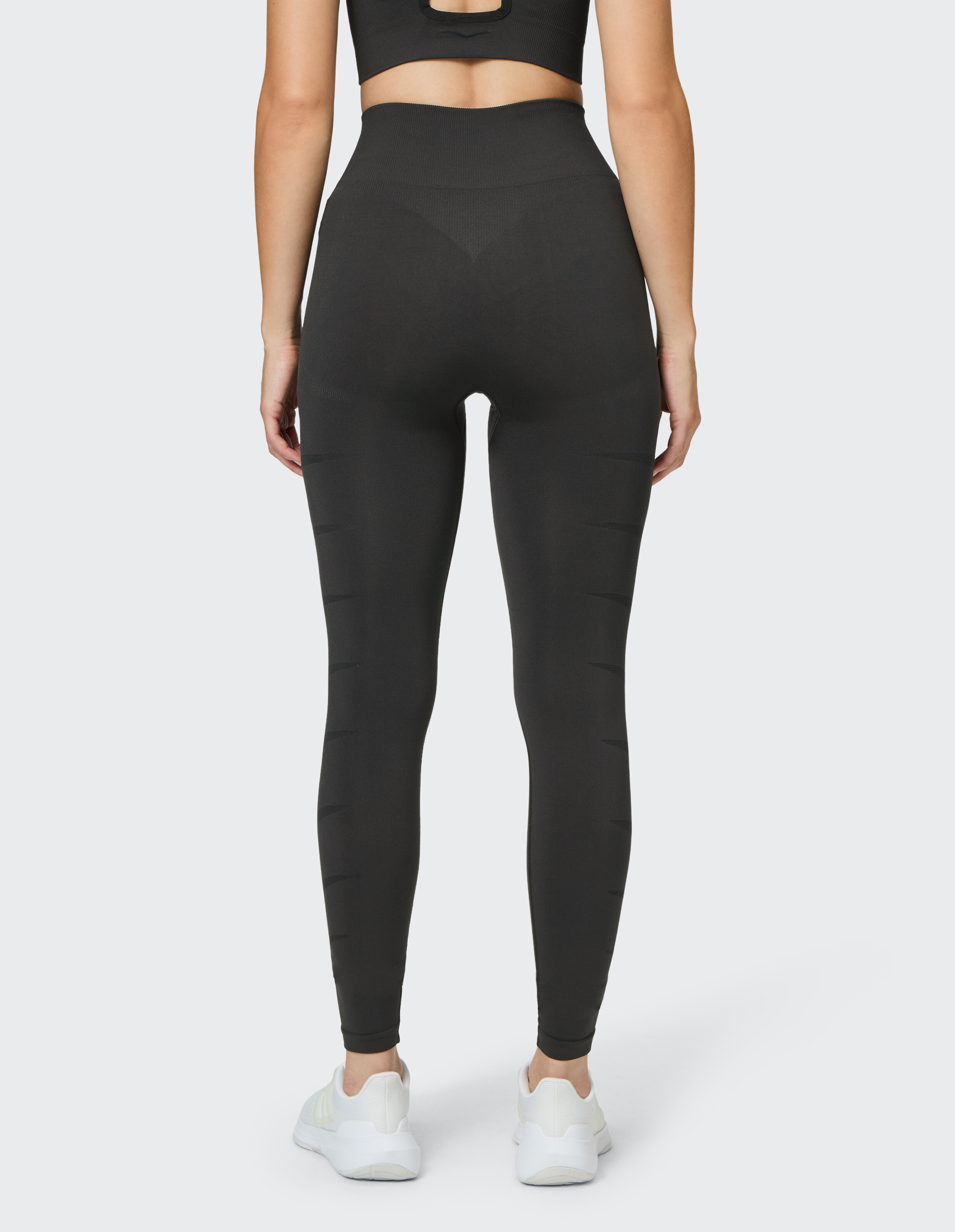 Rückansicht einer Frau in hoch taillierten schwarzen Leggings, perfekt für Freizeitkleidung.